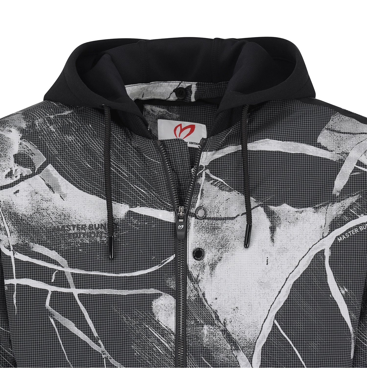 A close-up of a black and white graphic zip-up hoodie with a black hood and drawstrings, featuring a white brand label with a red logo.