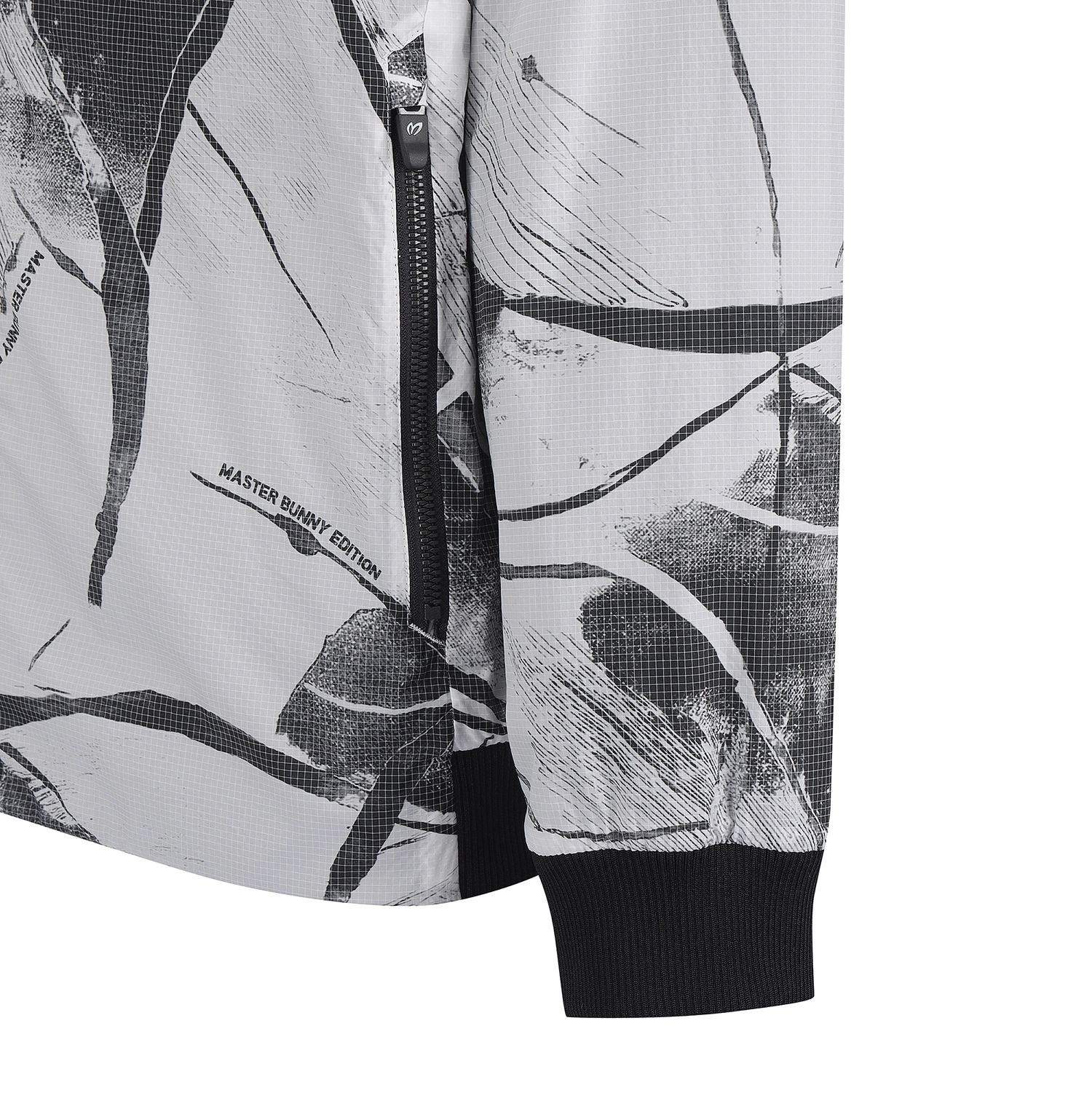 Close-up of a zip-front jacket sleeve and body showing a black and white abstract brushstroke pattern, black ribbed cuff, and small visible text reading 'MASTER BUNNY EDITION'.