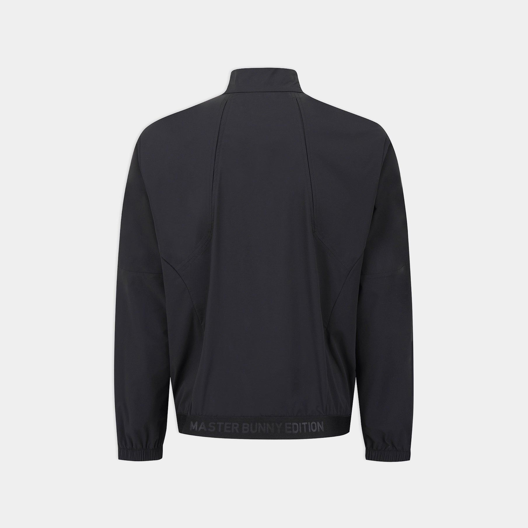 A black long-sleeve athletic jacket shown from the back, featuring a mock neck, zippered side pockets, and a black elastic hem with 'MASTER BUNNY EDITION' text, set against a light gray background.