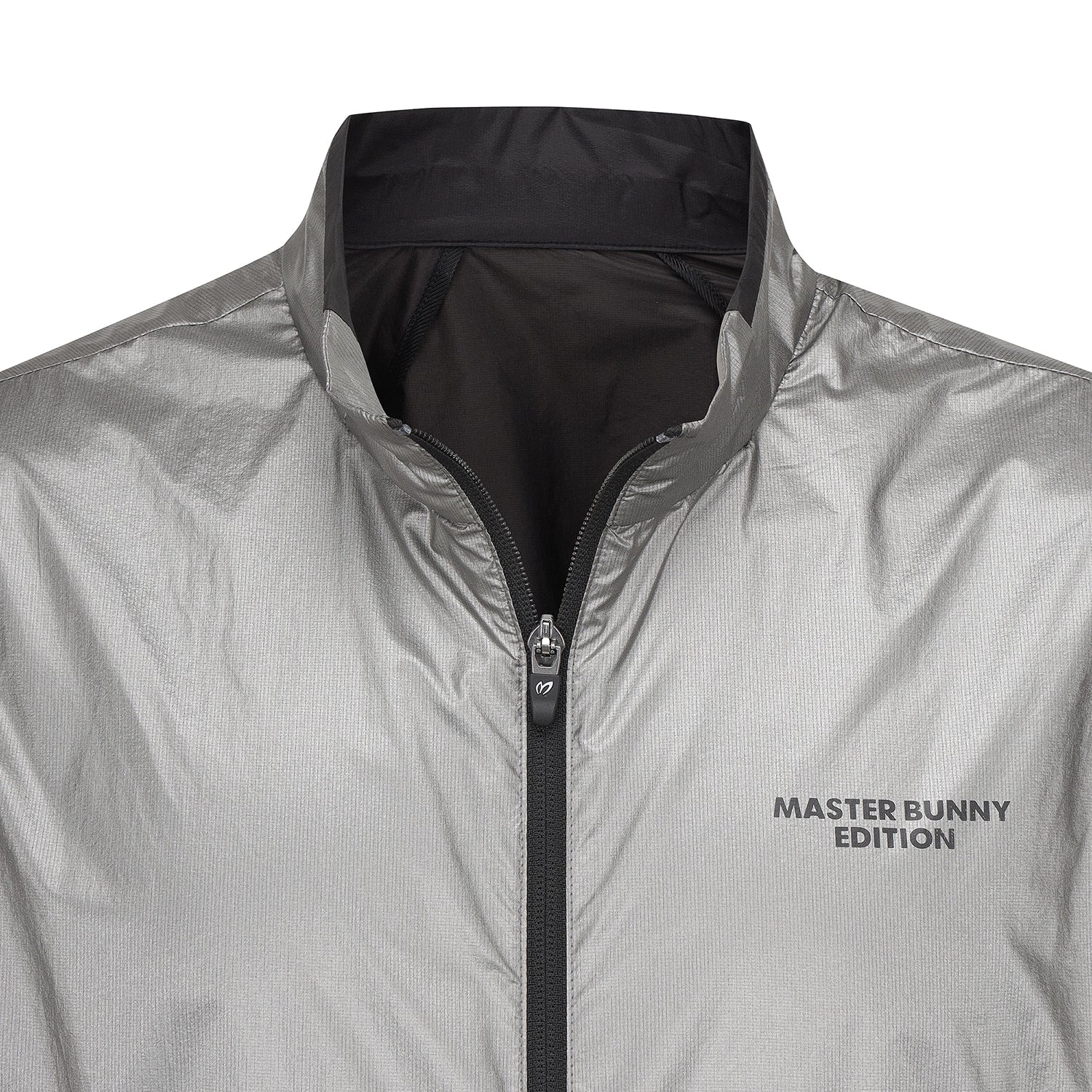 Close-up of a lightweight silver jacket with a black zipper, black collar lining, and 'MASTER BUNNY EDITION' printed in black on the left chest.