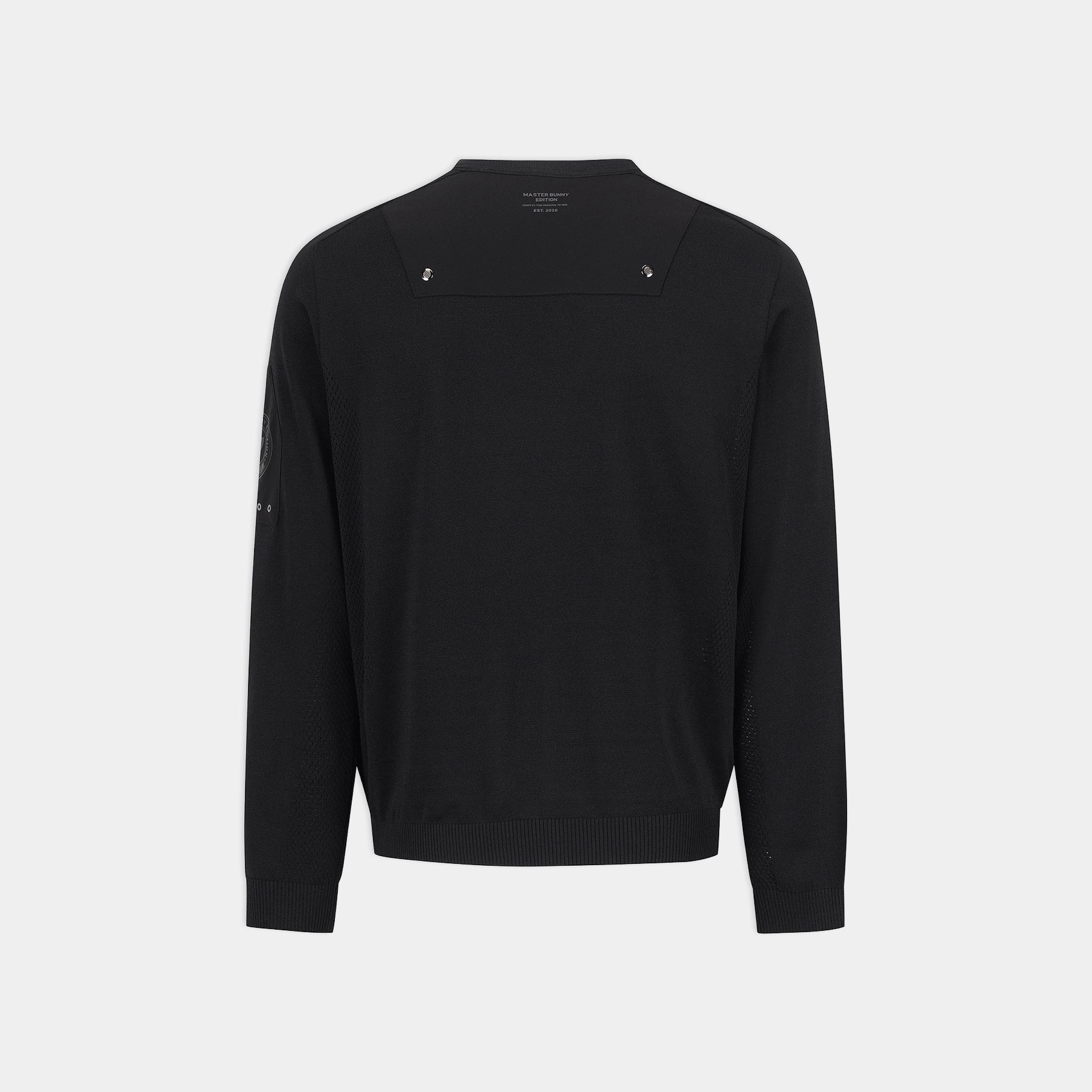 A black long-sleeve knit sweater shown from the back, featuring a wide shoulder yoke with two small silver-tone decorative studs and ribbed cuffs and hem, on a light gray background.