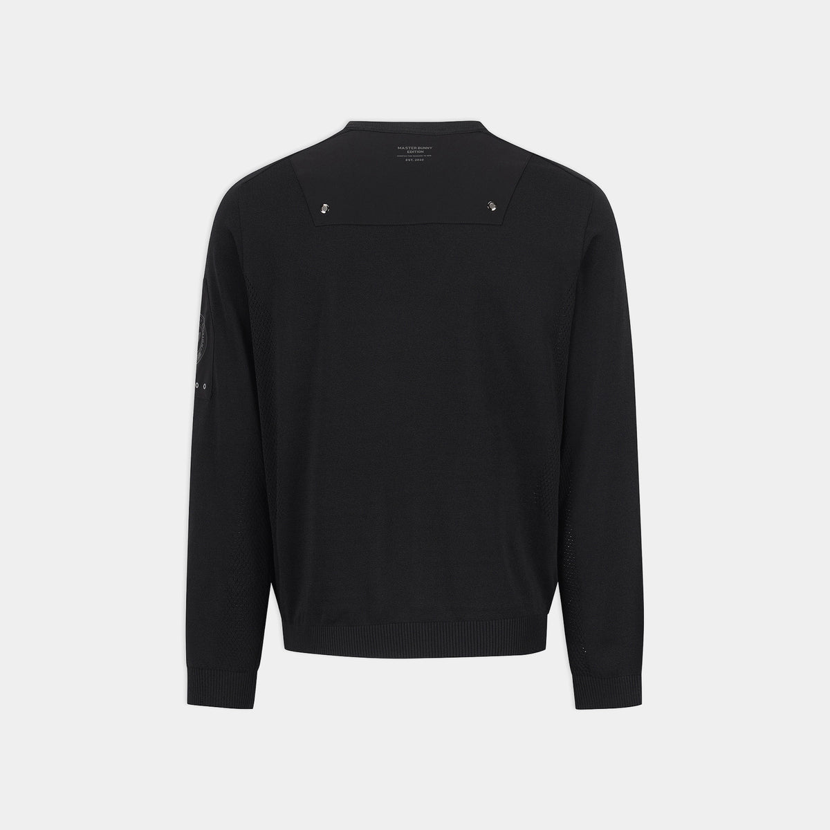 A black long-sleeve knit sweater shown from the back, featuring a wide shoulder yoke with two small silver-tone decorative studs and ribbed cuffs and hem, on a light gray background.