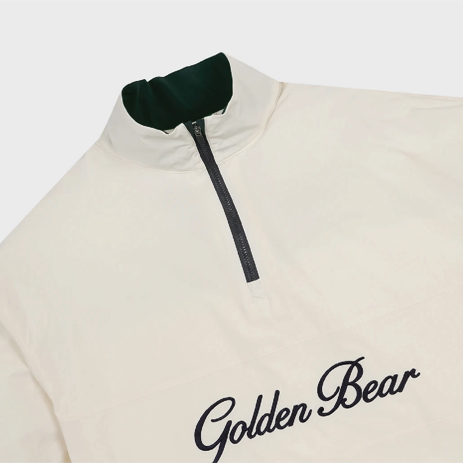 An off-white quarter-zip pullover jacket with a dark green inner collar and black 'Golden Bear' script embroidery on the chest, shown against a light gray background.