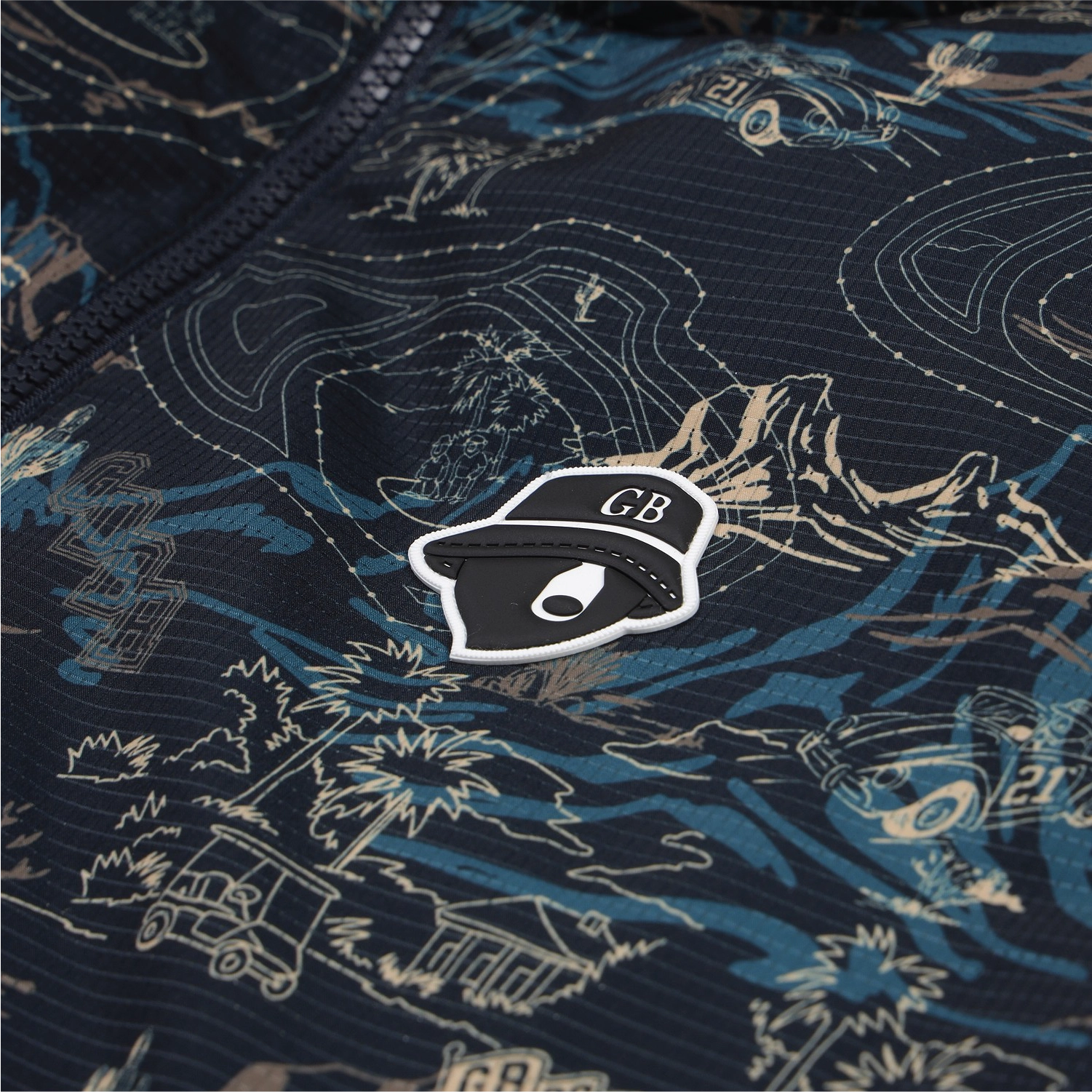 A close-up of a dark navy zippered jacket with a blue and beige topographic map pattern, featuring a black and white CB hat patch on the chest.