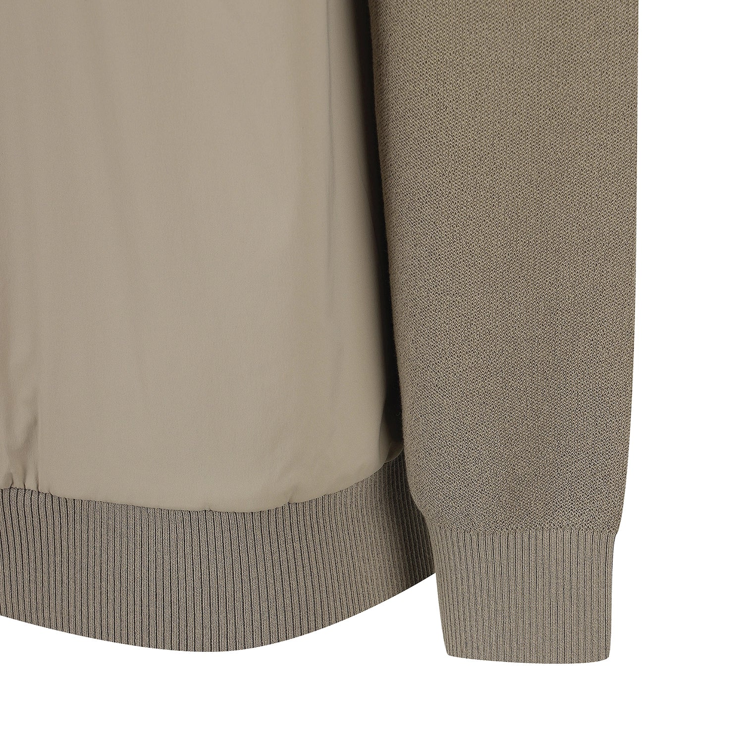 Close-up detail of a beige and taupe knit and smooth fabric jacket, showing the ribbed hem and sleeve cuff on a white background.