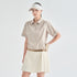 A model wearing a beige short-sleeve collared polo shirt with a matching beige belt and an off-white pleated golf skirt, paired with an off-white visor, against a light gray studio background.