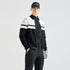 A man modeling a black and white color-blocked zip-up jacket, black pants, a black cap with &