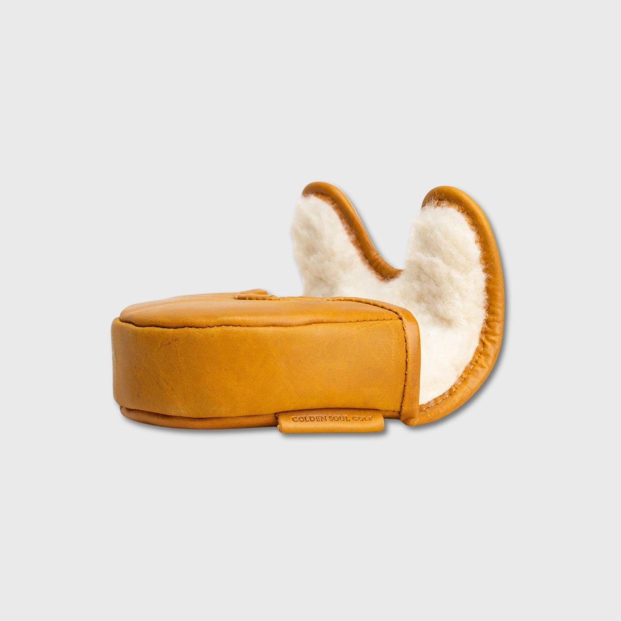 A single tan leather OZ1 Putter Cover with a white sherpa lining, shown from the side against a light gray background.