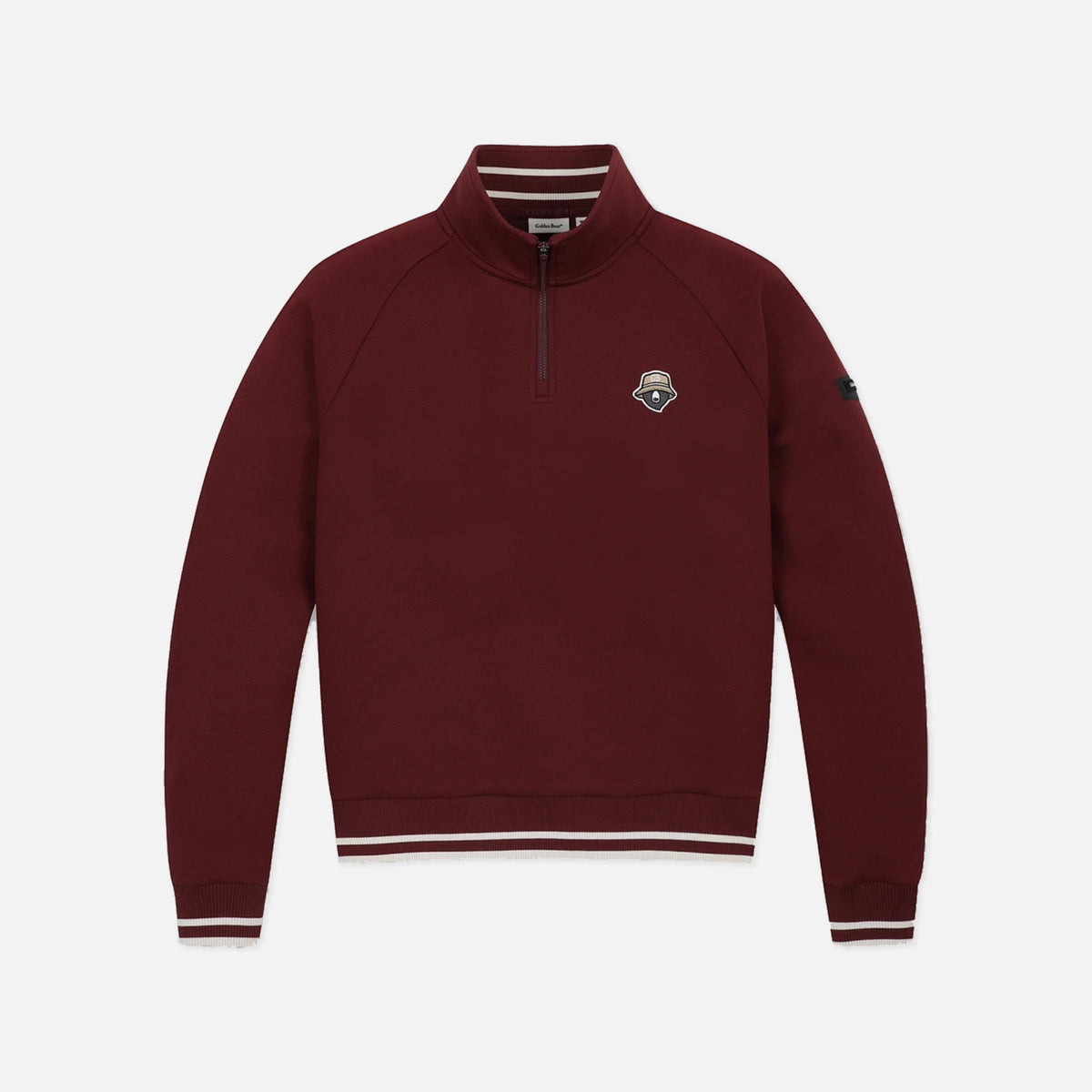 A maroon long-sleeve quarter-zip pullover sweatshirt with white striped ribbing on the collar, cuffs, and hem, featuring a small embroidered shield logo on the left chest.