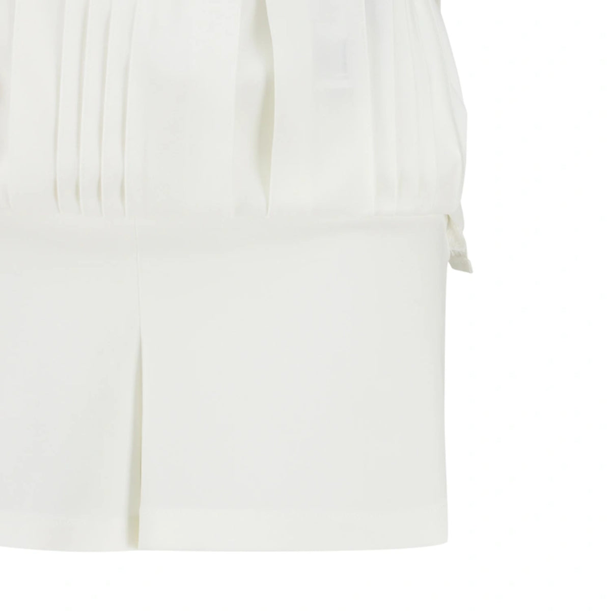 Close-up of a white pleated garment, showing the fabric texture and pleated details against a white background.