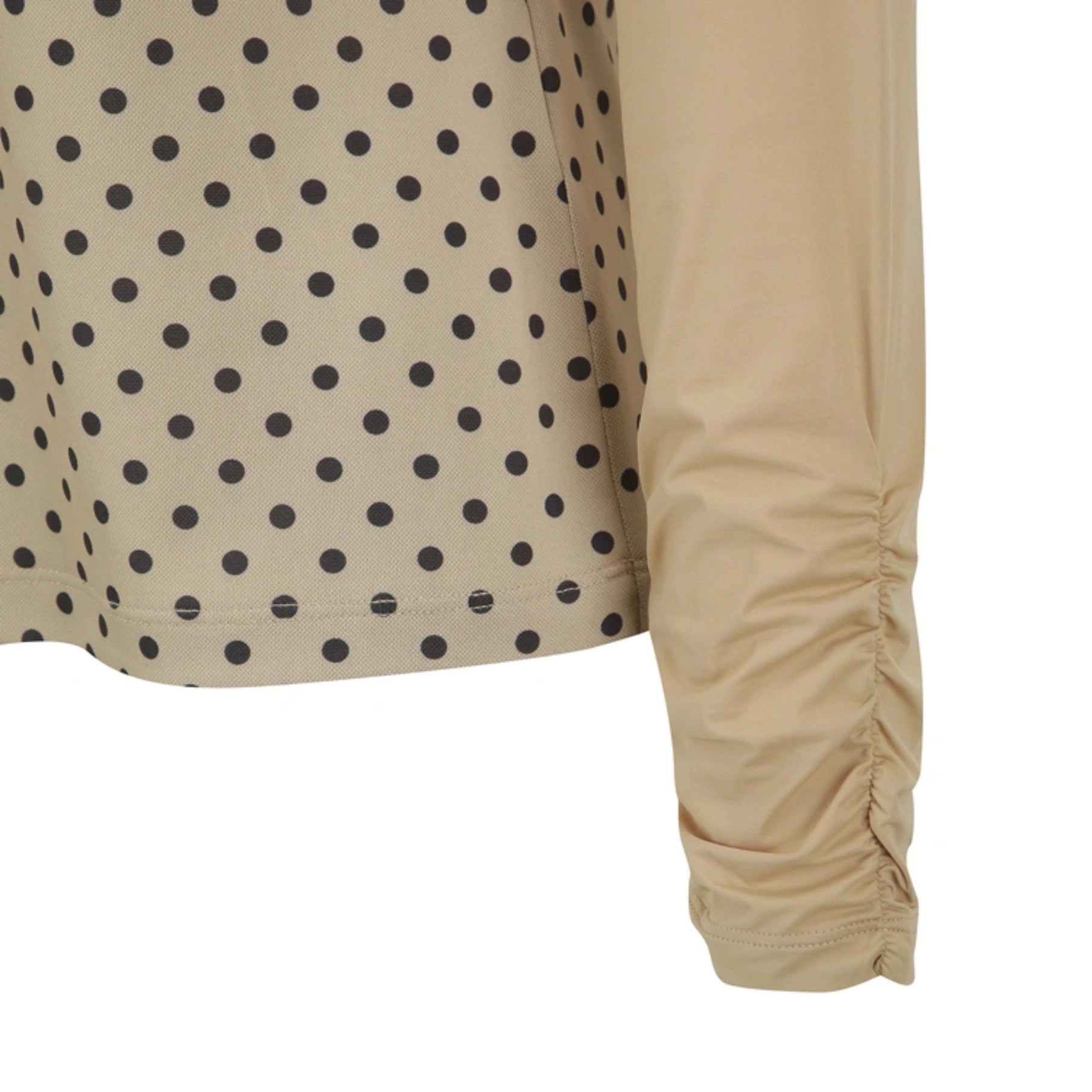 Close-up of a beige long-sleeve top with black polka dots on the body and a solid beige ruched sleeve, shown against a white background.
