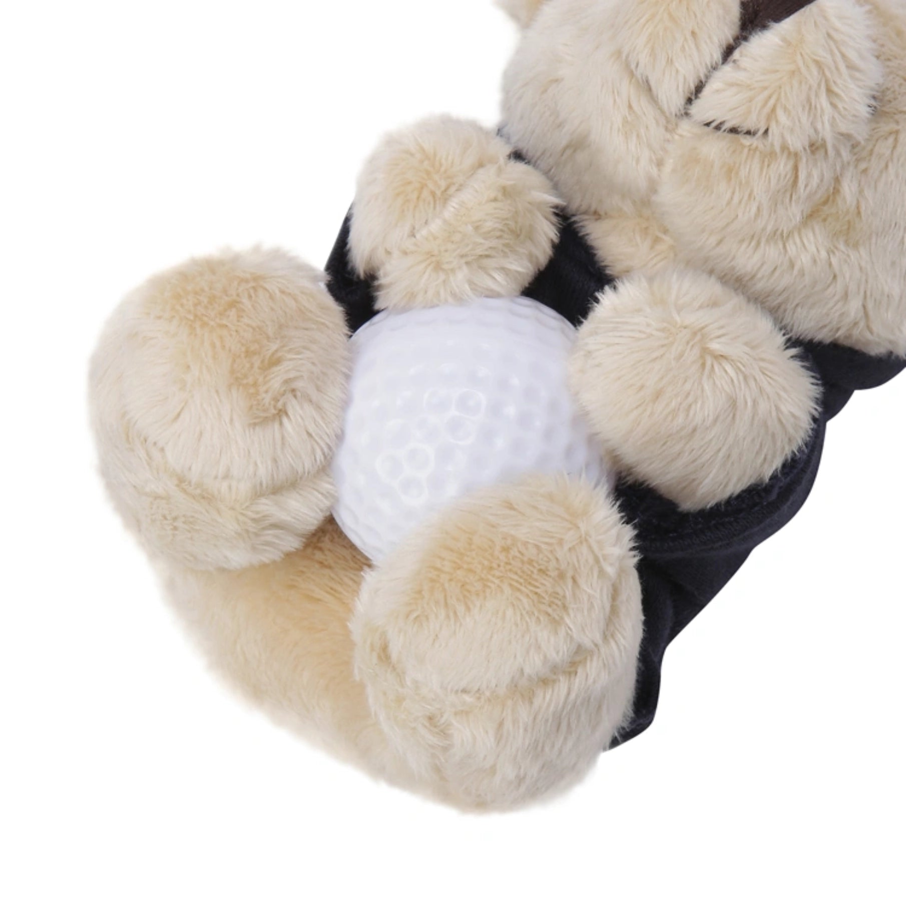 Close-up of a plush teddy bear wearing a black shirt and holding a white golf ball, shown against a plain white background.