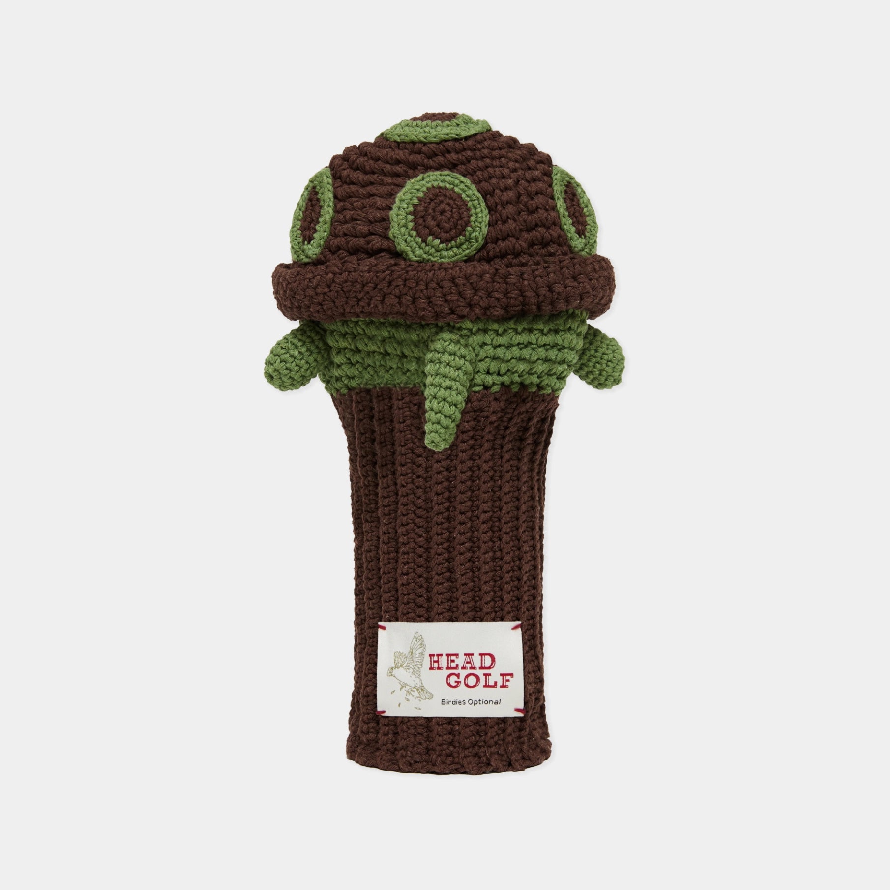 A crocheted golf club headcover shaped like a turtle, featuring a dark brown body with green spots and a white label that reads 'HEAD GOLF' at the bottom, set against a plain light gray background.