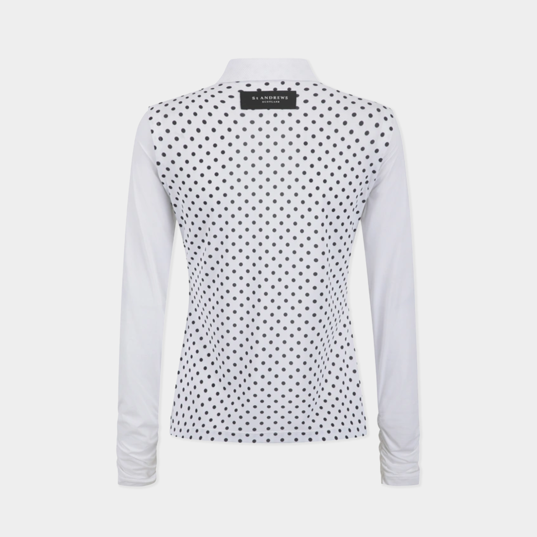 A women's long-sleeve collared top shown from the back, featuring a white base with an all-over black polka dot pattern and solid white sleeves.