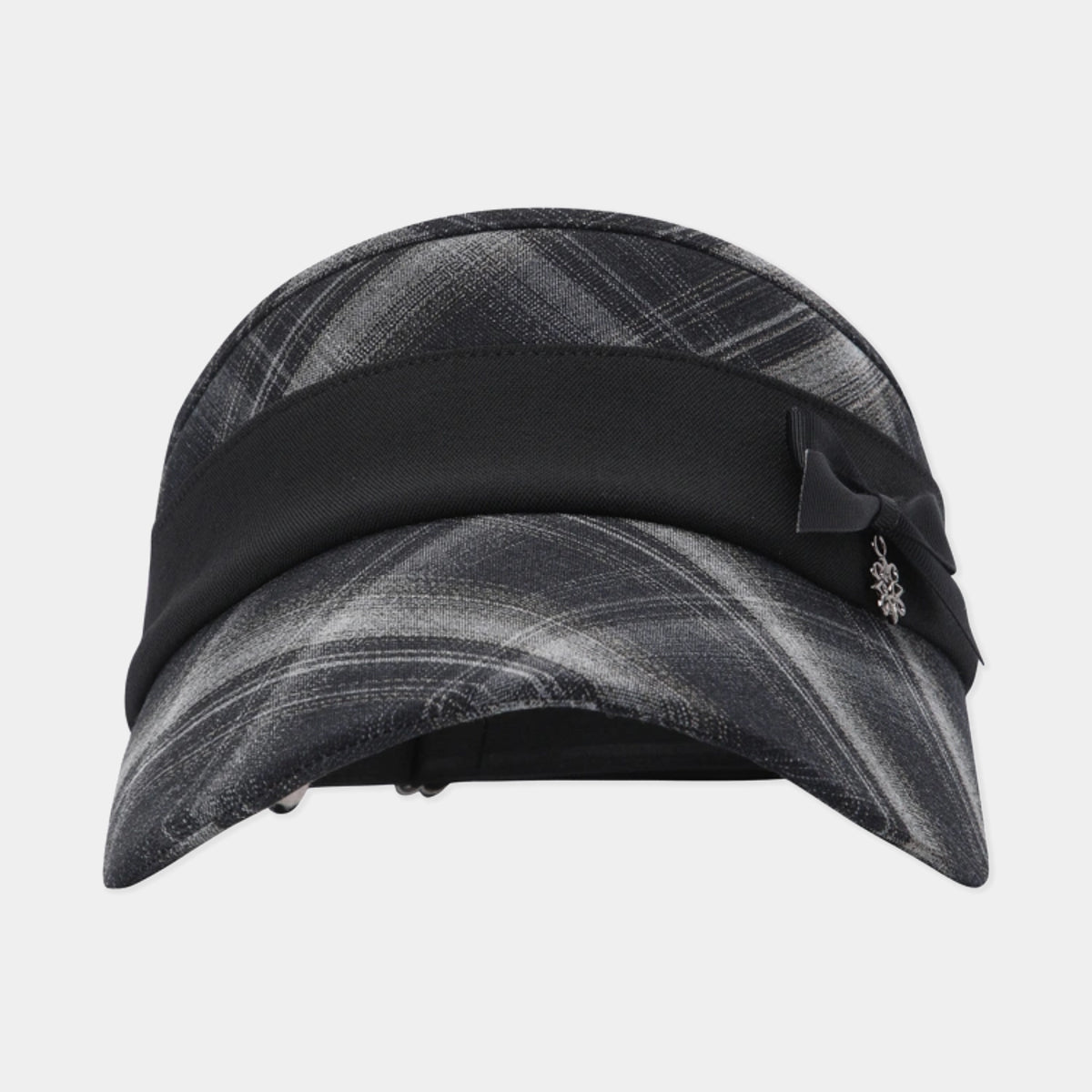 A black and gray plaid visor hat with a wide black band, a black bow, and a small silver floral charm, shown against a light gray background.