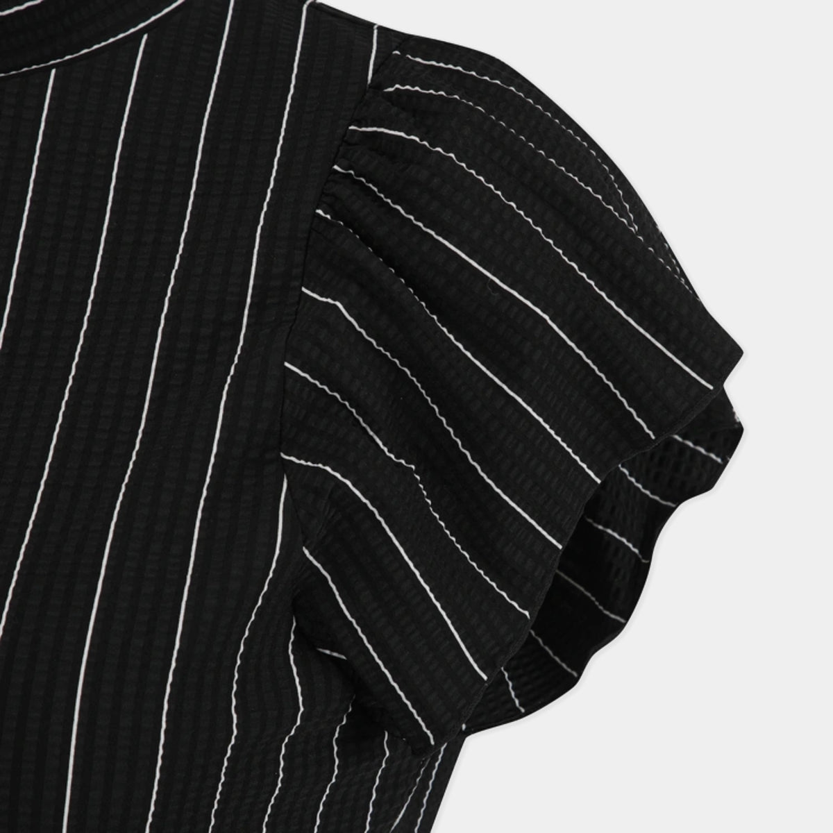 Close-up of a black textured top with white vertical pinstripes and a ruffled short sleeve, shown against a light gray background.