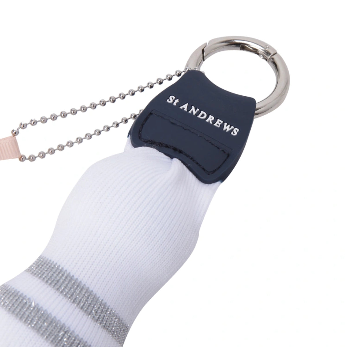 A close-up of a St Andrews knit sock keychain featuring a navy blue leather patch with the white embroidered brand name, attached to a silver ball chain and keyring.