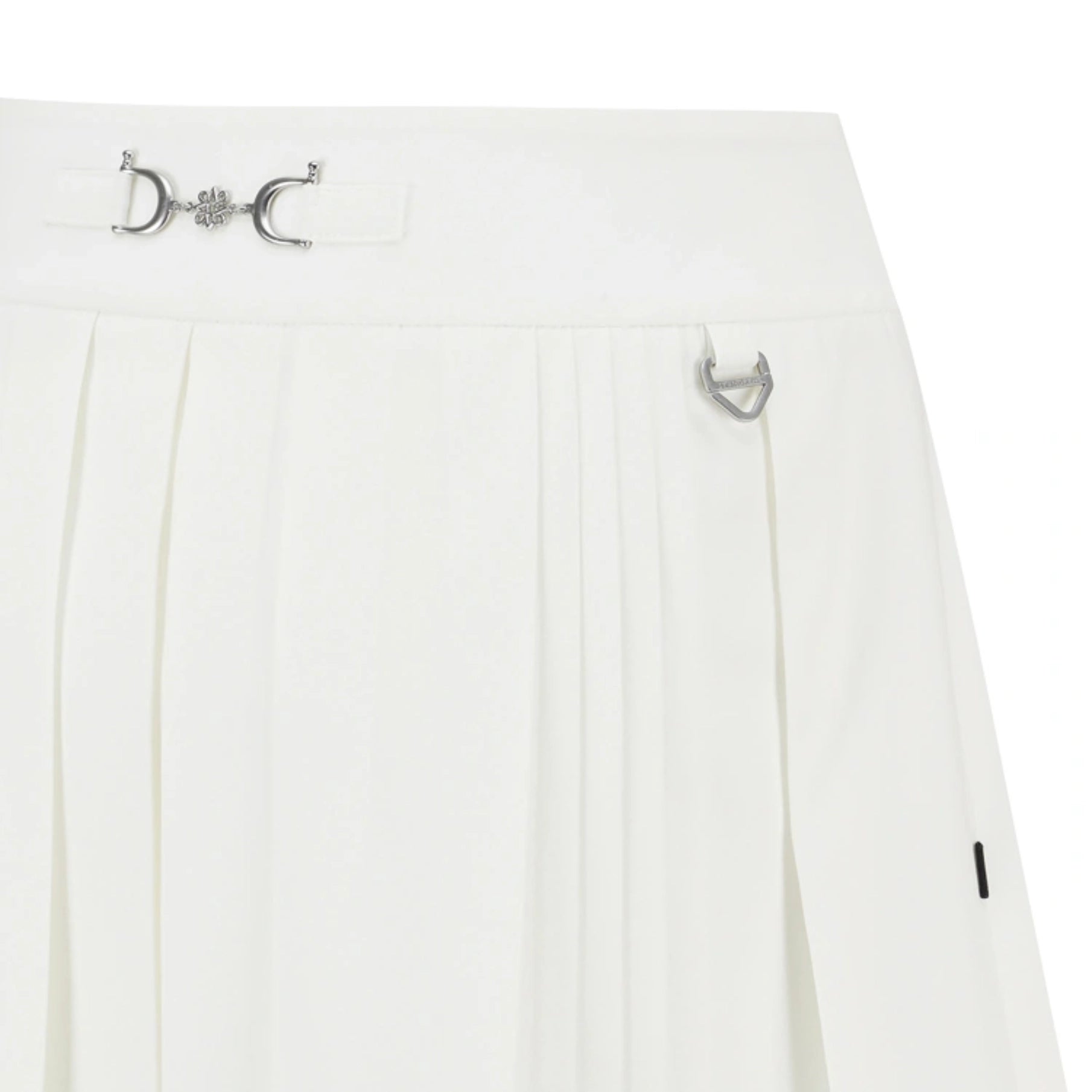 Close-up of a white pleated skirt with a silver horsebit hardware detail at the waistband and a small silver ring accent on the side.