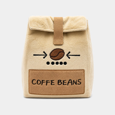 A beige plush head cover with a brown faux-leather strap and a front patch reading 'COFFEE BEANS' with a coffee bean graphic, shown on a light gray background.
