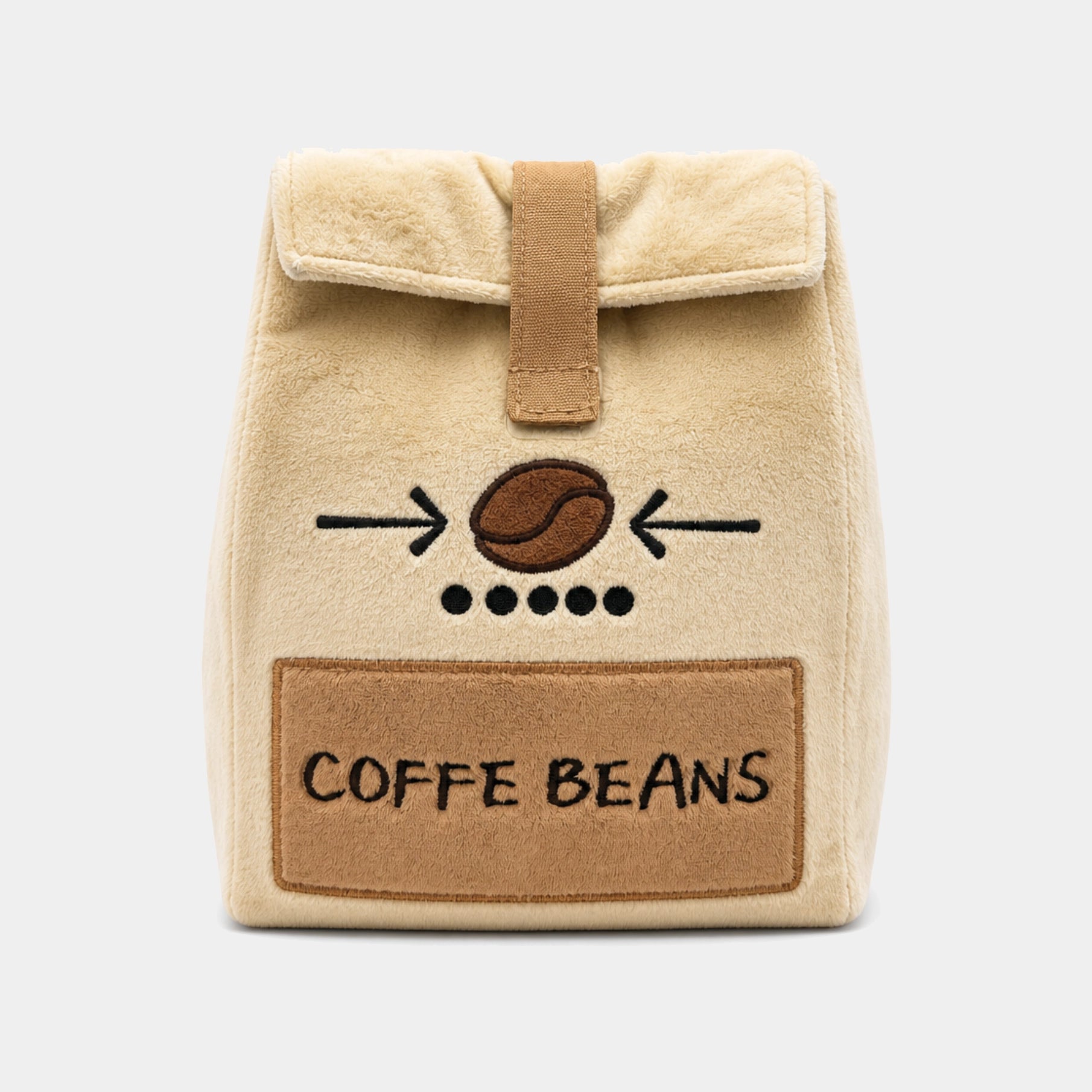 A beige plush head cover with a brown faux-leather strap and a front patch reading 'COFFEE BEANS' with a coffee bean graphic, shown on a light gray background.