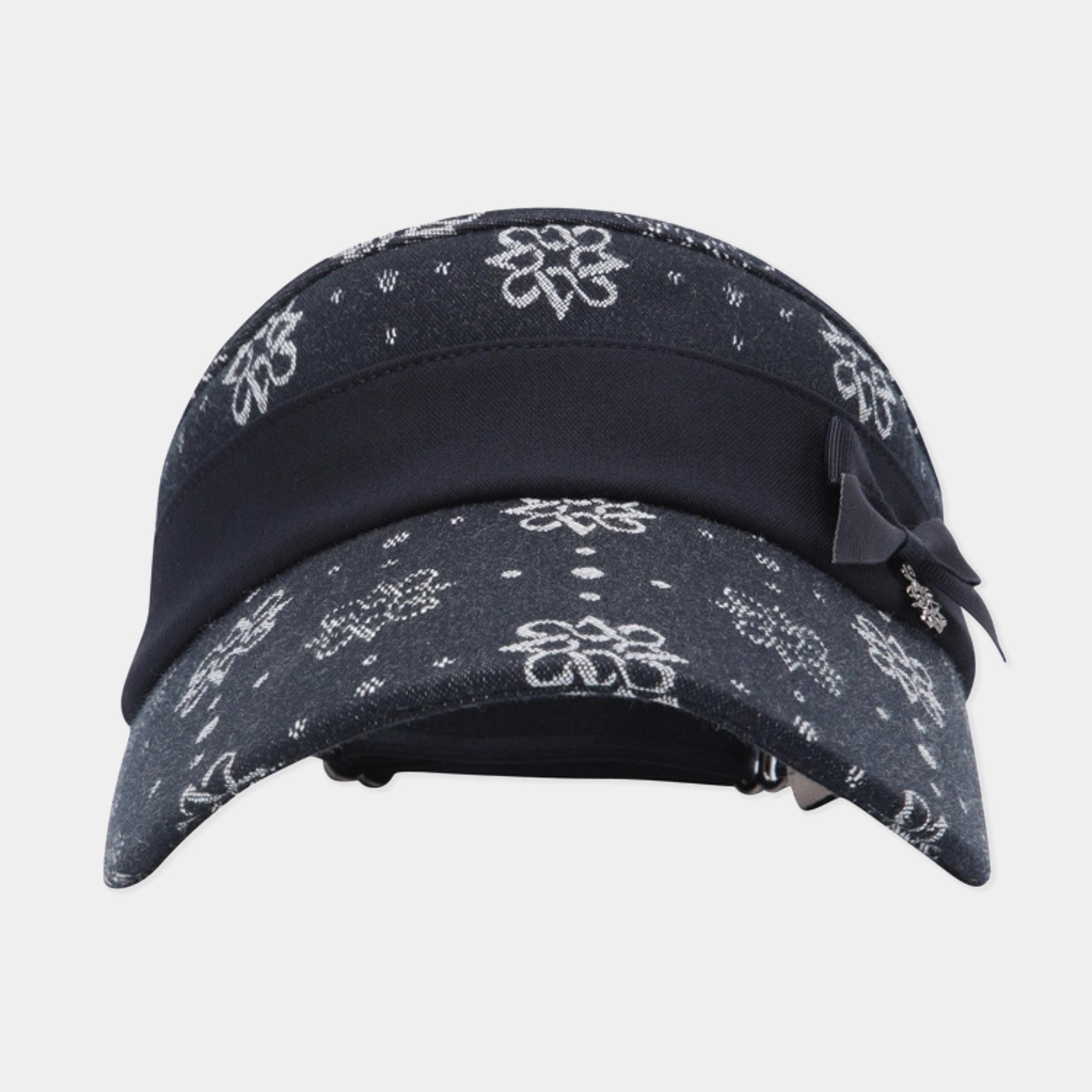 A dark navy blue bandana cap with a white floral and dotted bandana print, featuring a solid navy blue visor band and a matching navy ribbon bow on the side.