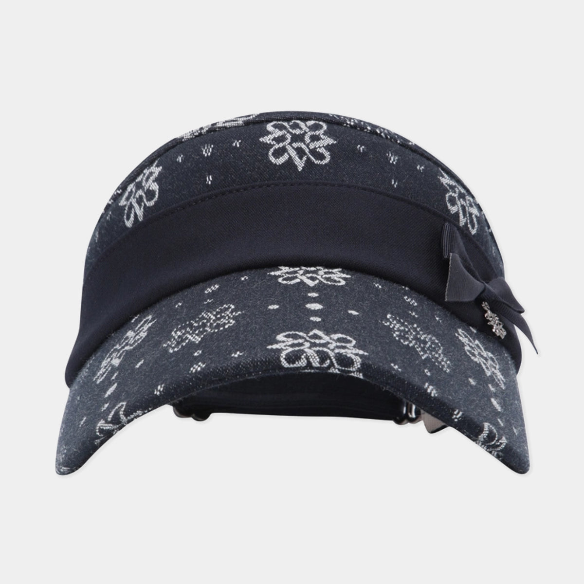 A dark navy blue bandana cap with a white floral and dotted bandana print, featuring a solid navy blue visor band and a matching navy ribbon bow on the side.