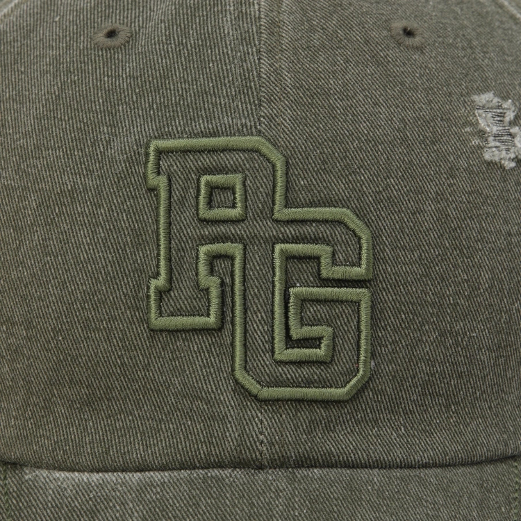 Close-up of an olive green baseball cap featuring a large embroidered 'RG' monogram logo on the front panel.