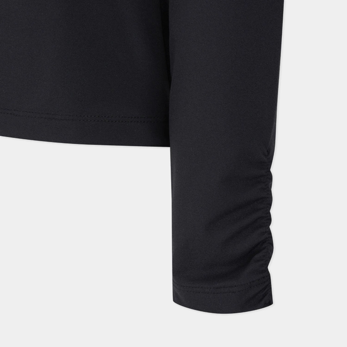 Close-up of a black long-sleeve athletic top showing the sleeve cuff with gathered ruching and a clean hem, on a light gray background.