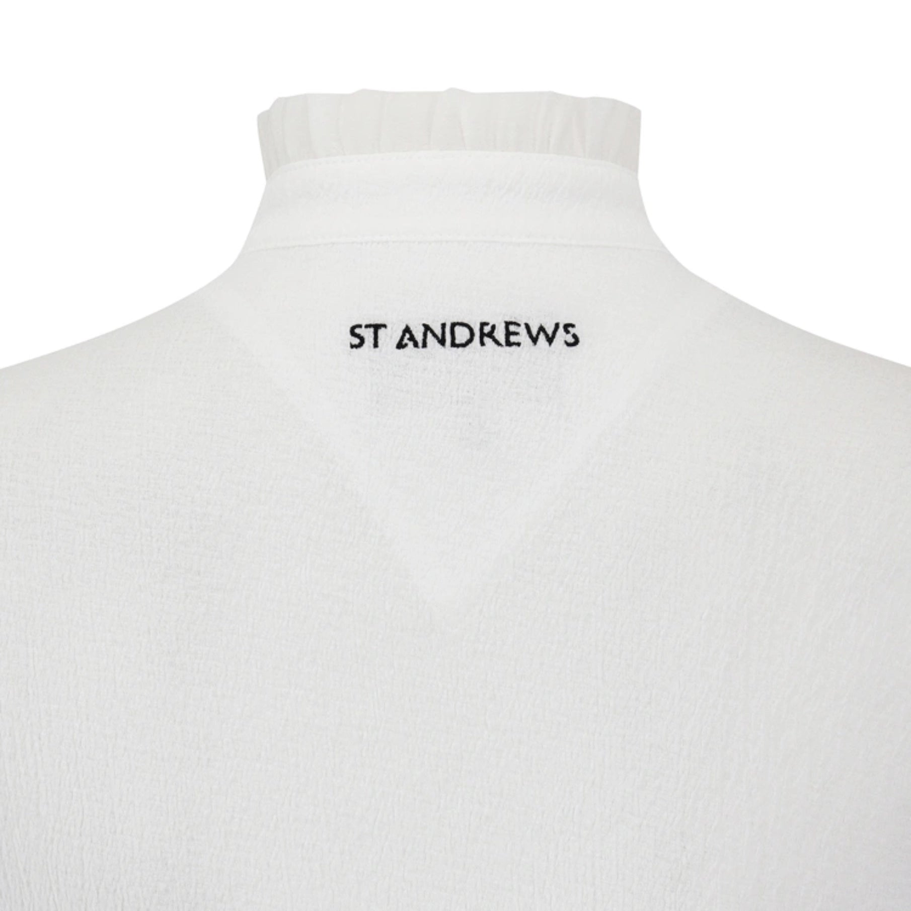 Close-up of the back of a white mock-neck sweater or turtleneck top on a mannequin, with 'ST ANDREWS' printed in black text at the center of the neck.
