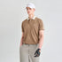 A man modeling a tan short-sleeve polo shirt with a beige collar and white stripes on the sleeves, paired with khaki pants, a white cap, and a black golf glove, against a light gray studio background.