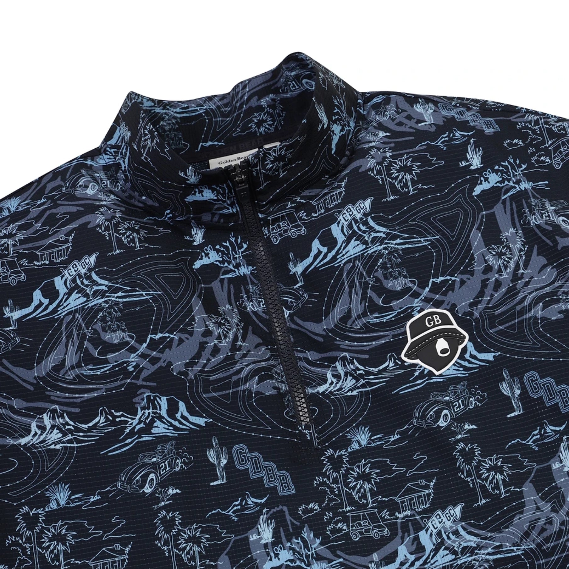 A close-up of a dark navy quarter-zip pullover with a light blue and white scenic print, featuring a small GB logo patch on the chest.