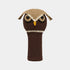 A crocheted owl-shaped golf club headcover in dark brown and tan, featuring embroidered eyes, a yellow beak, and ear tufts, shown against a light gray background.