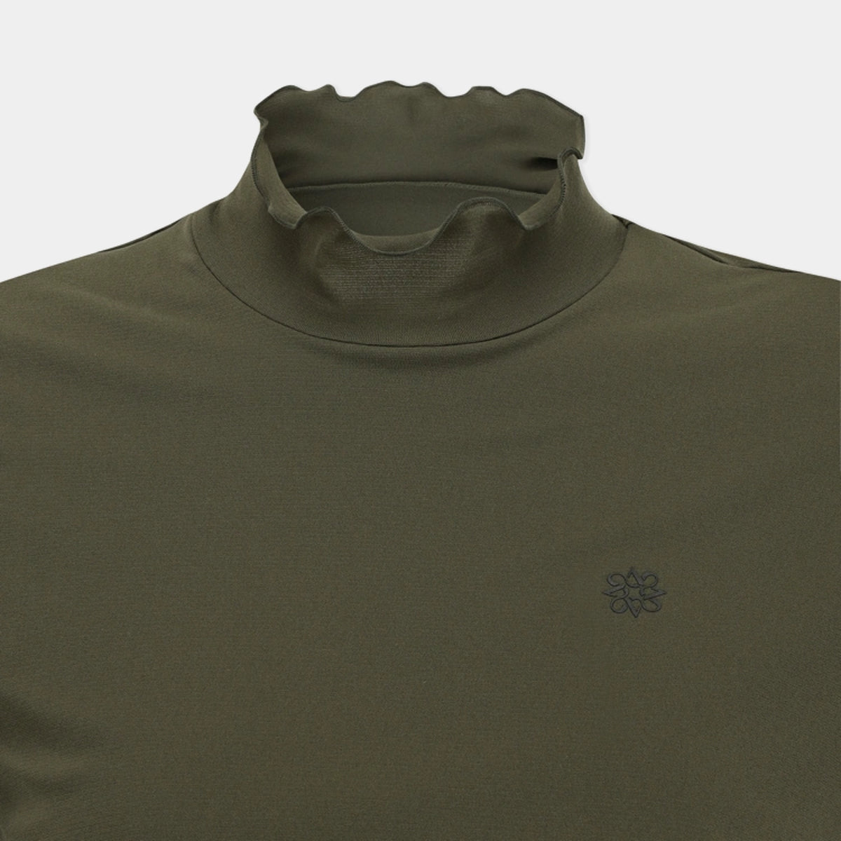 Close-up of an olive green long-sleeve top with a high folded mock neck collar and a small dark embroidered flower logo on the left chest, shown against a light gray background.