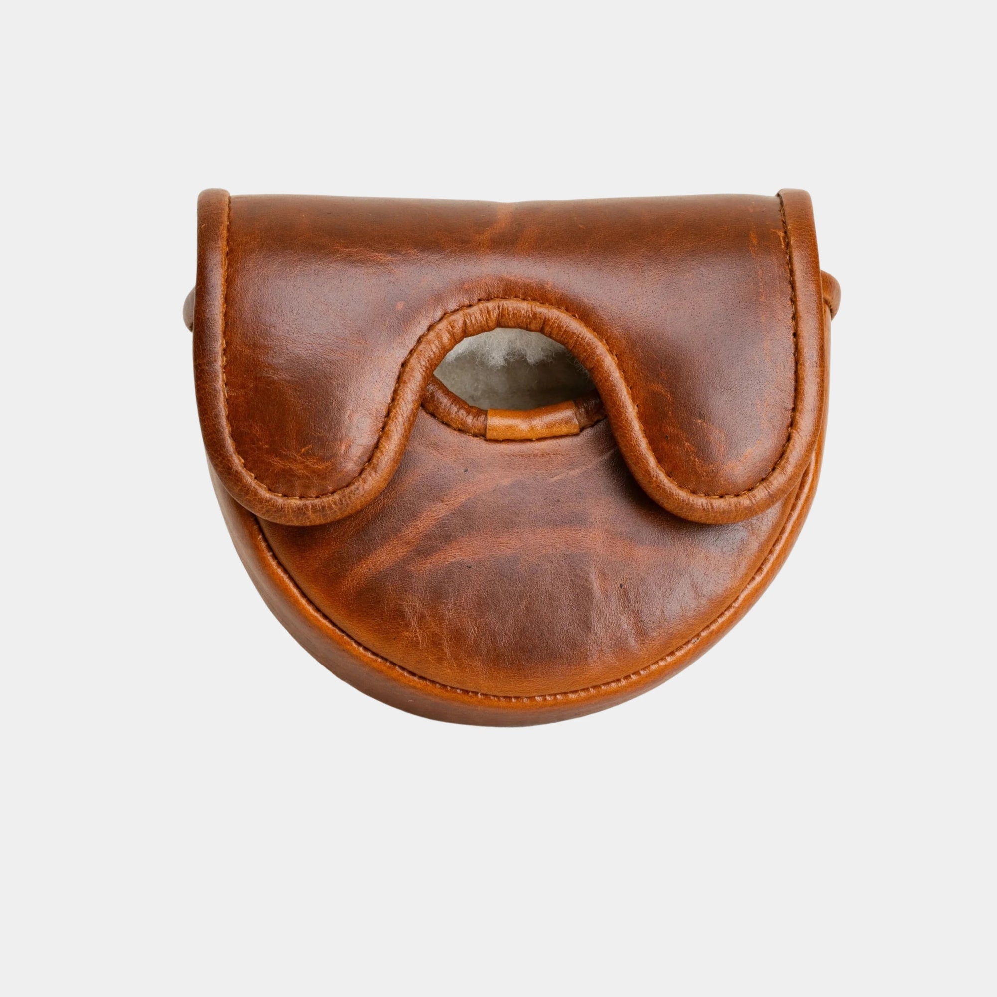 A brown leather OZ1 putter cover  with a curved, saddle-like shape and a central cutout, shown against a plain light gray background.