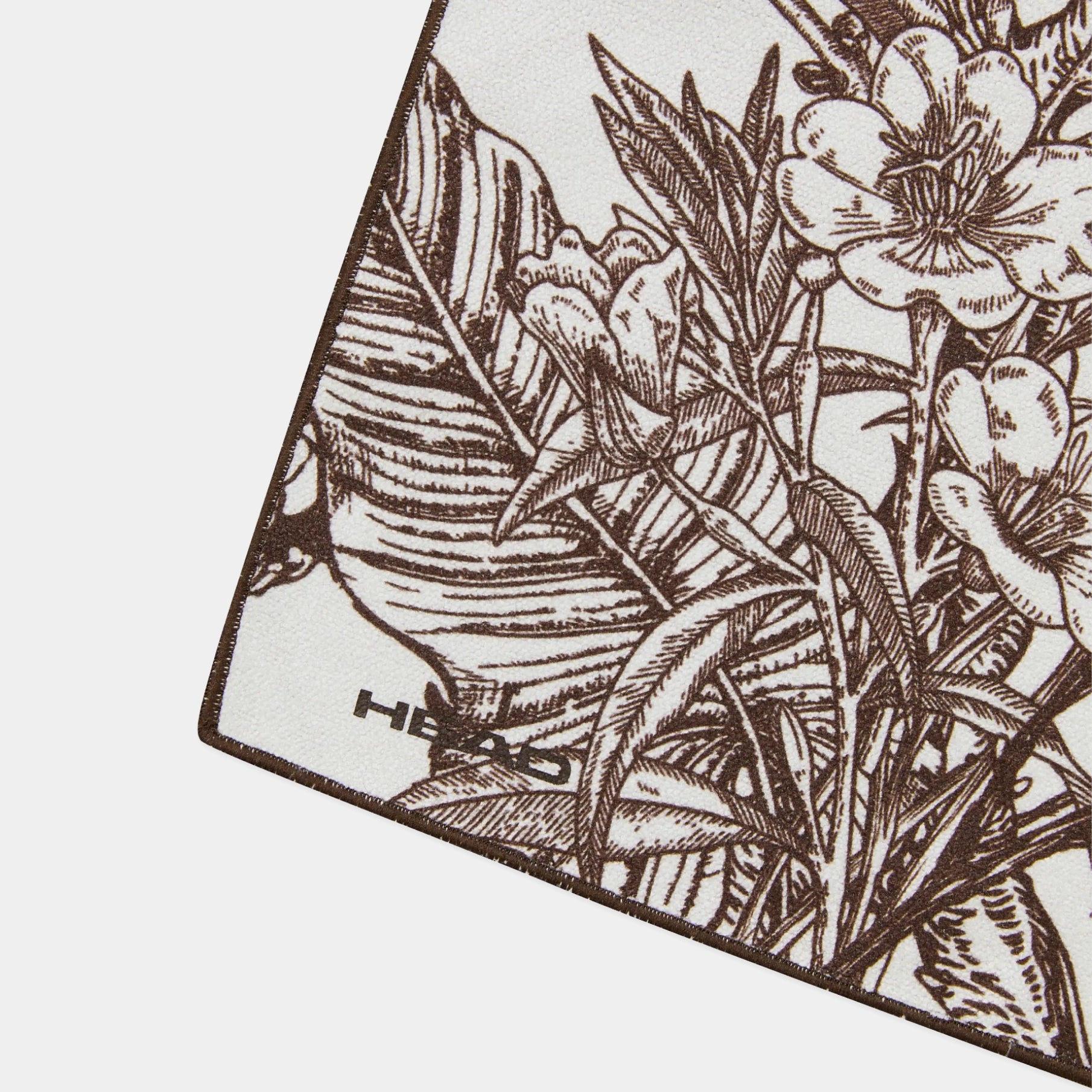 A close-up of a square scarf or fabric corner featuring a brown botanical line-art print on a white background, with the brand name HER visible near one corner.