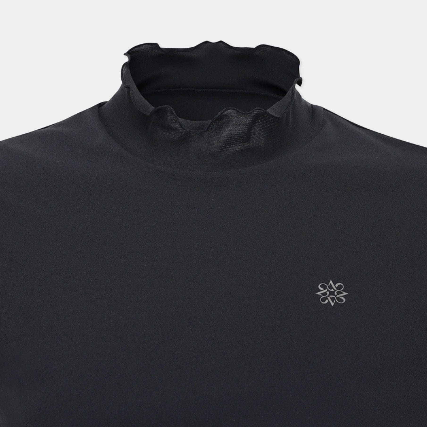 Close-up of a black athletic top with a high mock neck collar and a small silver geometric logo on the left chest, shown against a light gray background.