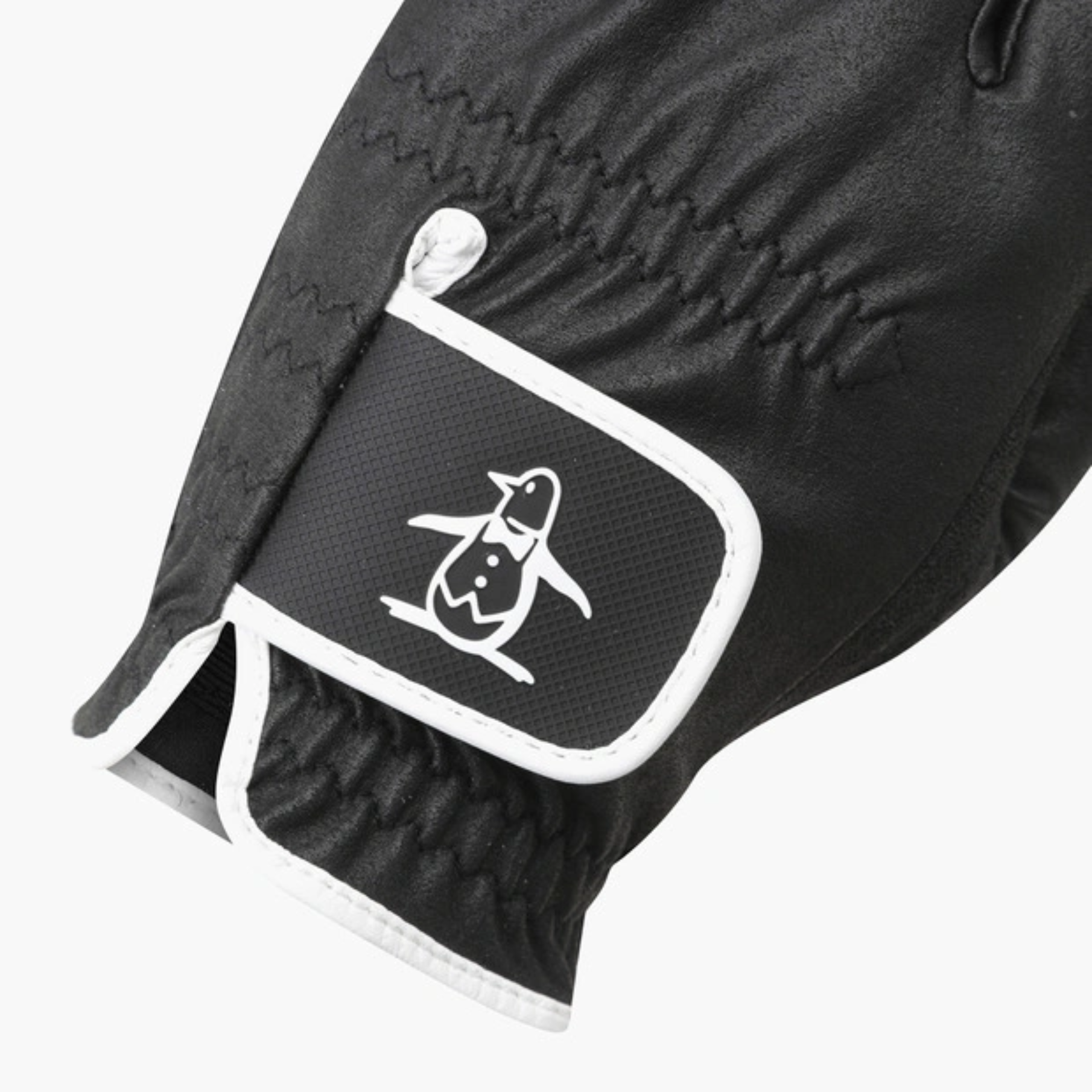Close-up of a black glove with a white-trimmed patch featuring a white penguin logo, shown on a light gray background.