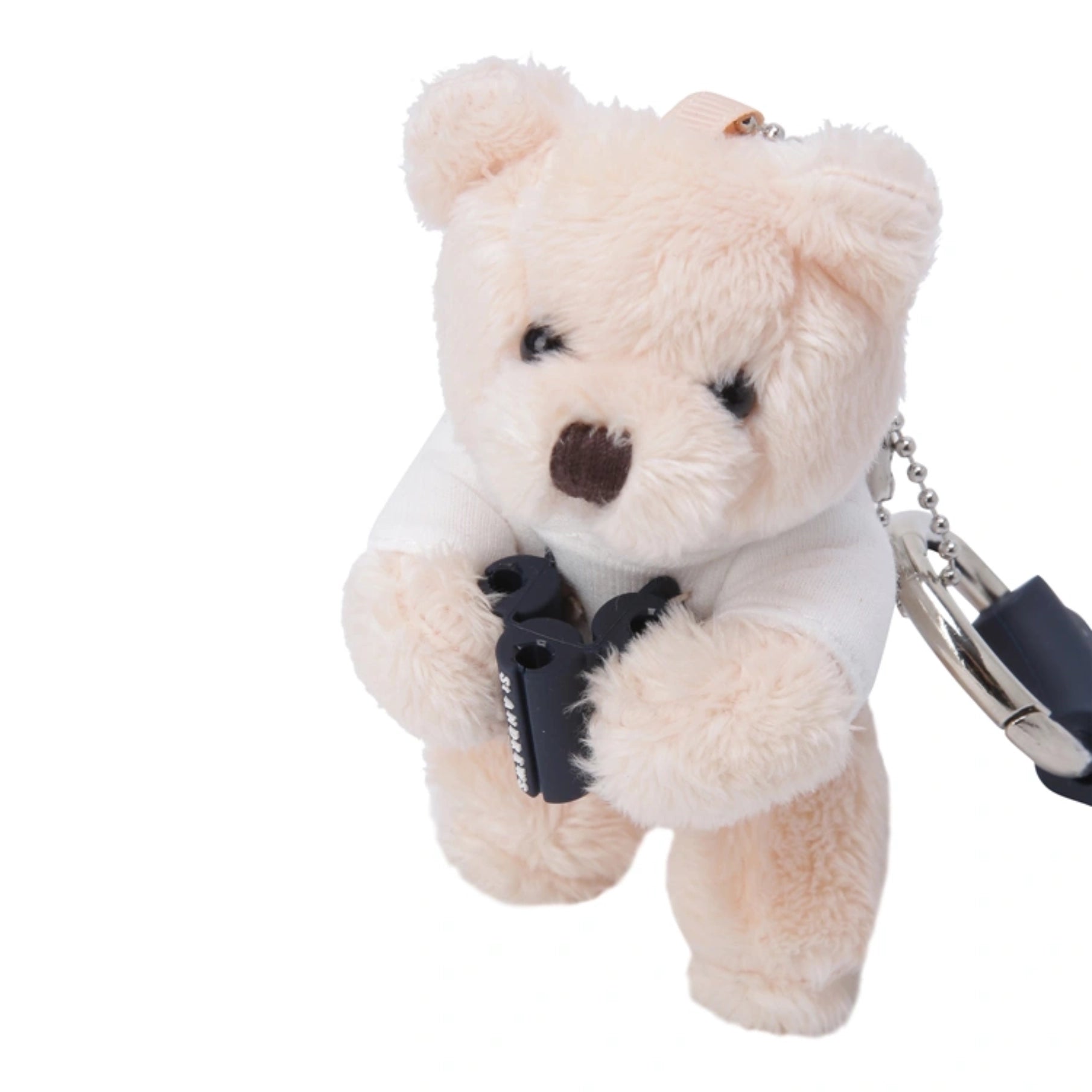A plush teddy bear keychain in a light cream color, holding a small black toy gun, with a silver metal ball chain and lock attached on the right side, set against a plain white background.