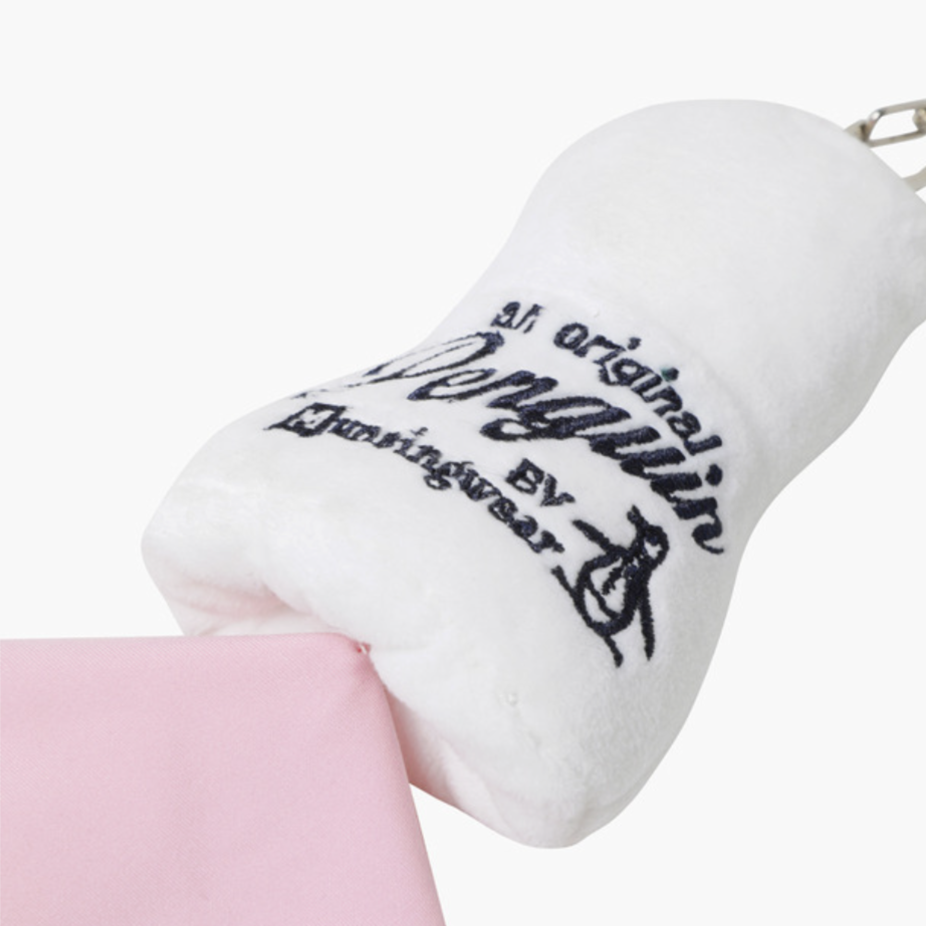 A white plush golf teedie keychain with black embroidered text reading 'All original Penguin by Huntingwear' and a small metal key ring, shown against a light gray background with a pink fabric prop at the bottom.