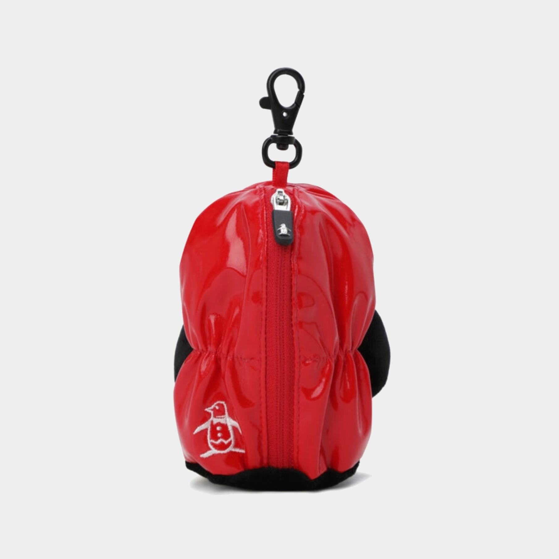 A red glossy puffer-style pouch with black trim, a black carabiner clip at the top, and a small white penguin logo near the bottom left, shown on a light gray background.