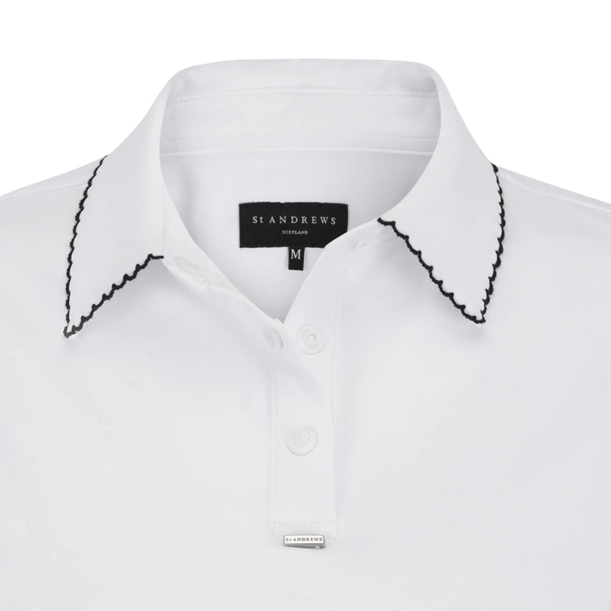 Close-up of a white St Andrews by St. John's shirt with black scalloped trim along the collar and a matching silver-toned cufflink.