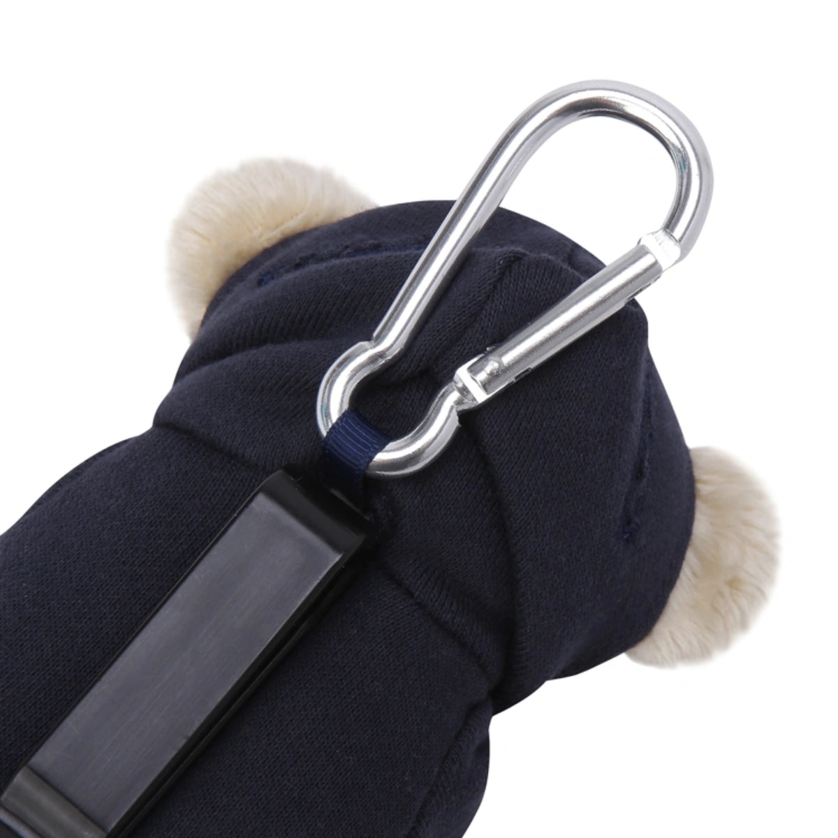 Close-up of a dark navy blue pet jacket with fluffy cream ear flaps and a silver metal carabiner attached, on a white background.