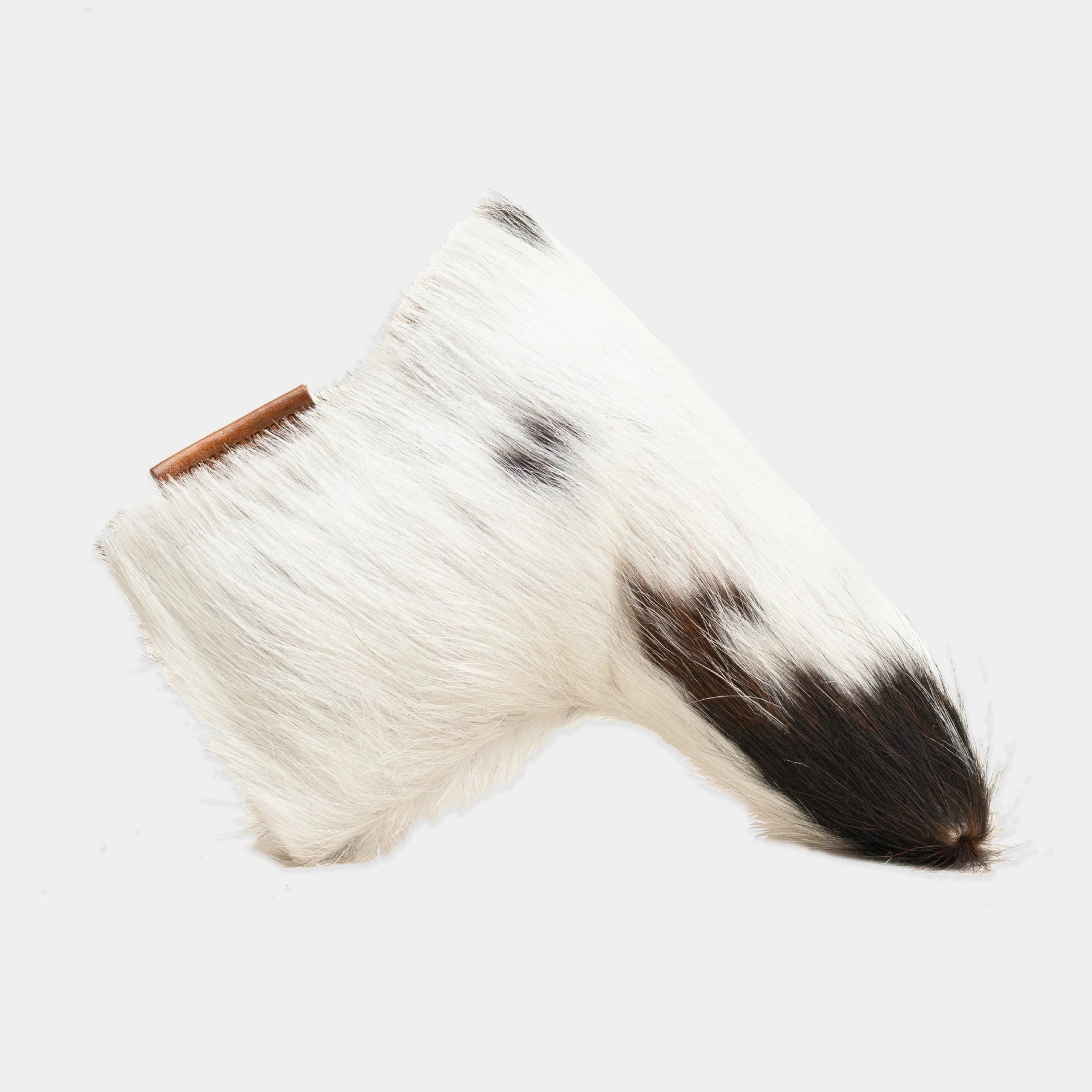 A white and black putter cover with a small brown leather tag, isolated on a light gray background.