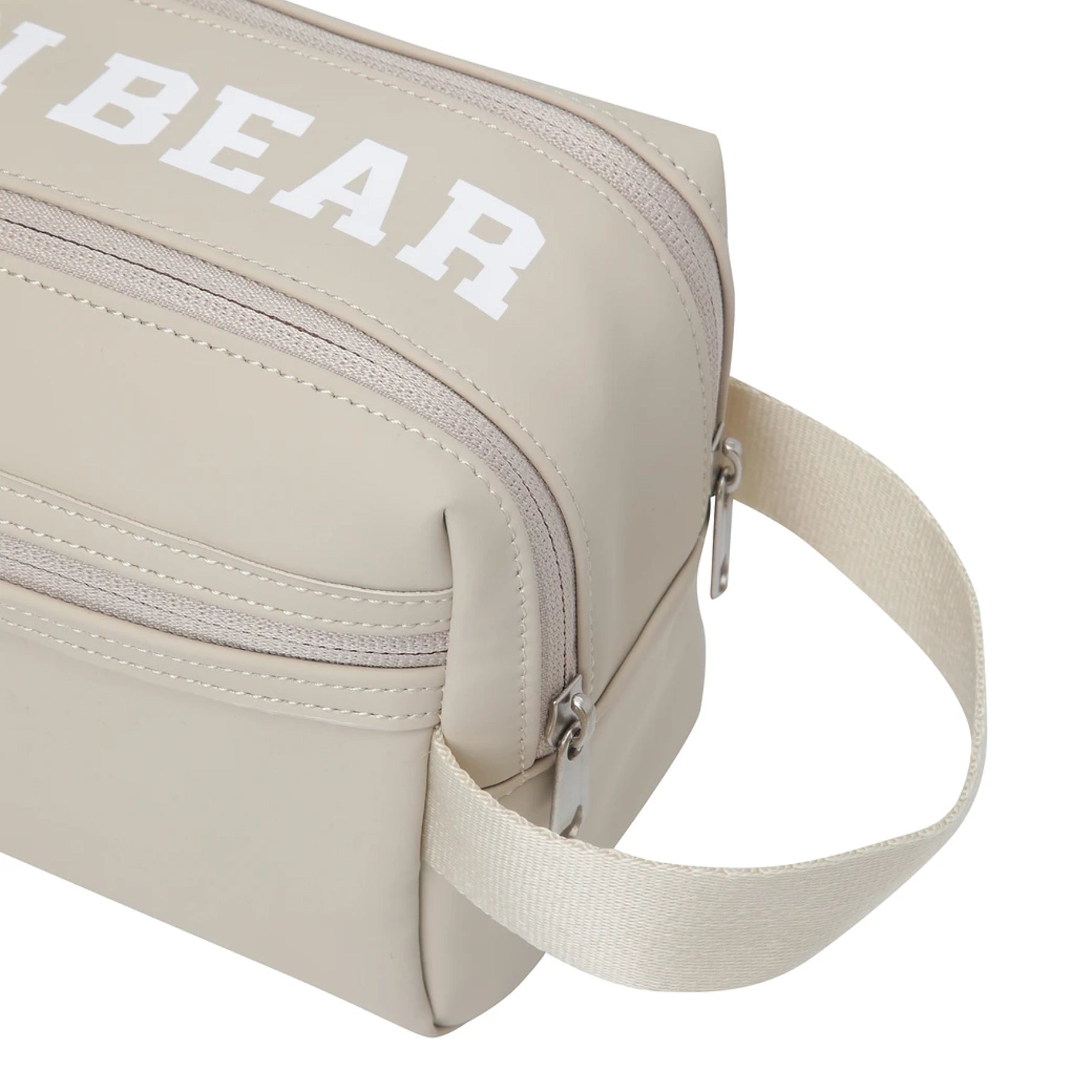 Beige nylon toiletry bag with a white 'GOLDEN BEAR' logo printed on the front, featuring a zippered compartment and an adjustable shoulder strap, shown on a white background.