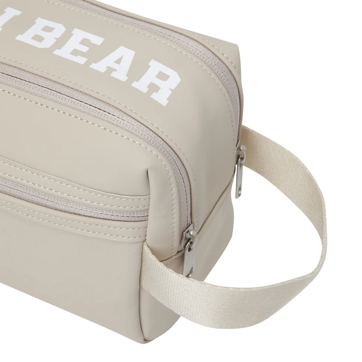 Beige nylon toiletry bag with a white 'GOLDEN BEAR' logo printed on the front, featuring a zippered compartment and an adjustable shoulder strap, shown on a white background.