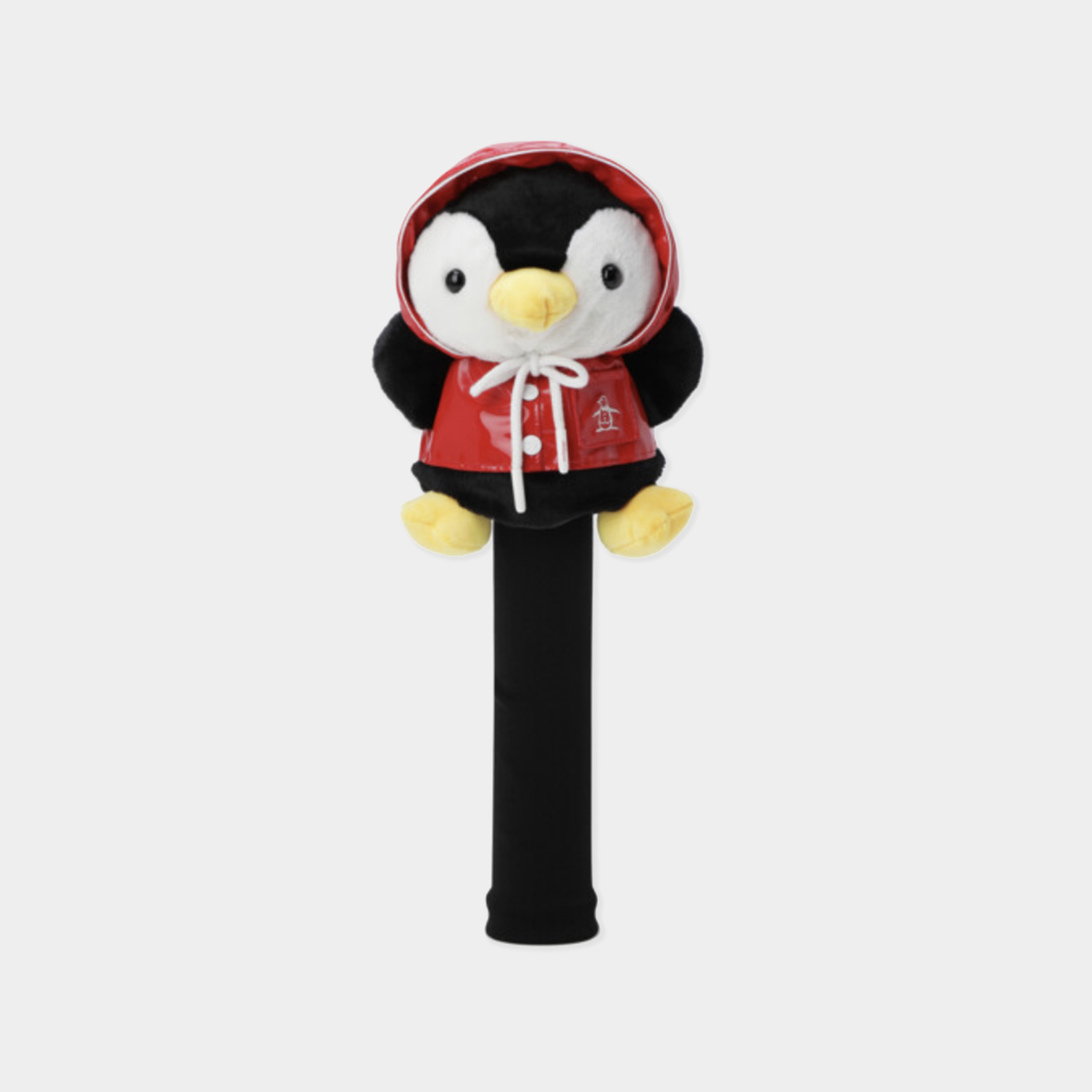 A plush penguin headcover on a black golf club shaft, dressed in a red hooded jacket with white drawstrings and yellow accents, set against a light gray background.