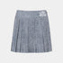 A pleated mini skirt in a textured slate blue-gray fabric, featuring a white embroidered floral accent on the left side of the waistband, shown against a light gray background.
