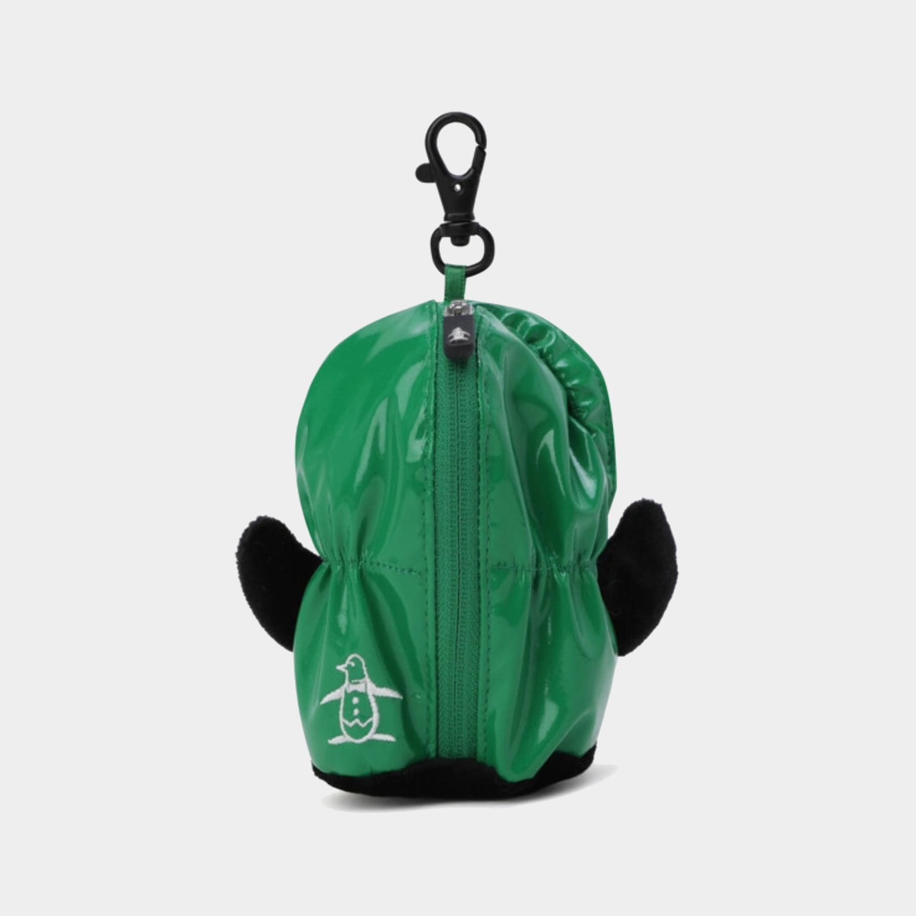 A green waterproof penguin-shaped golf ball case with black plush ears, a black lobster clasp, and a white penguin logo on the front, shown against a light gray background.