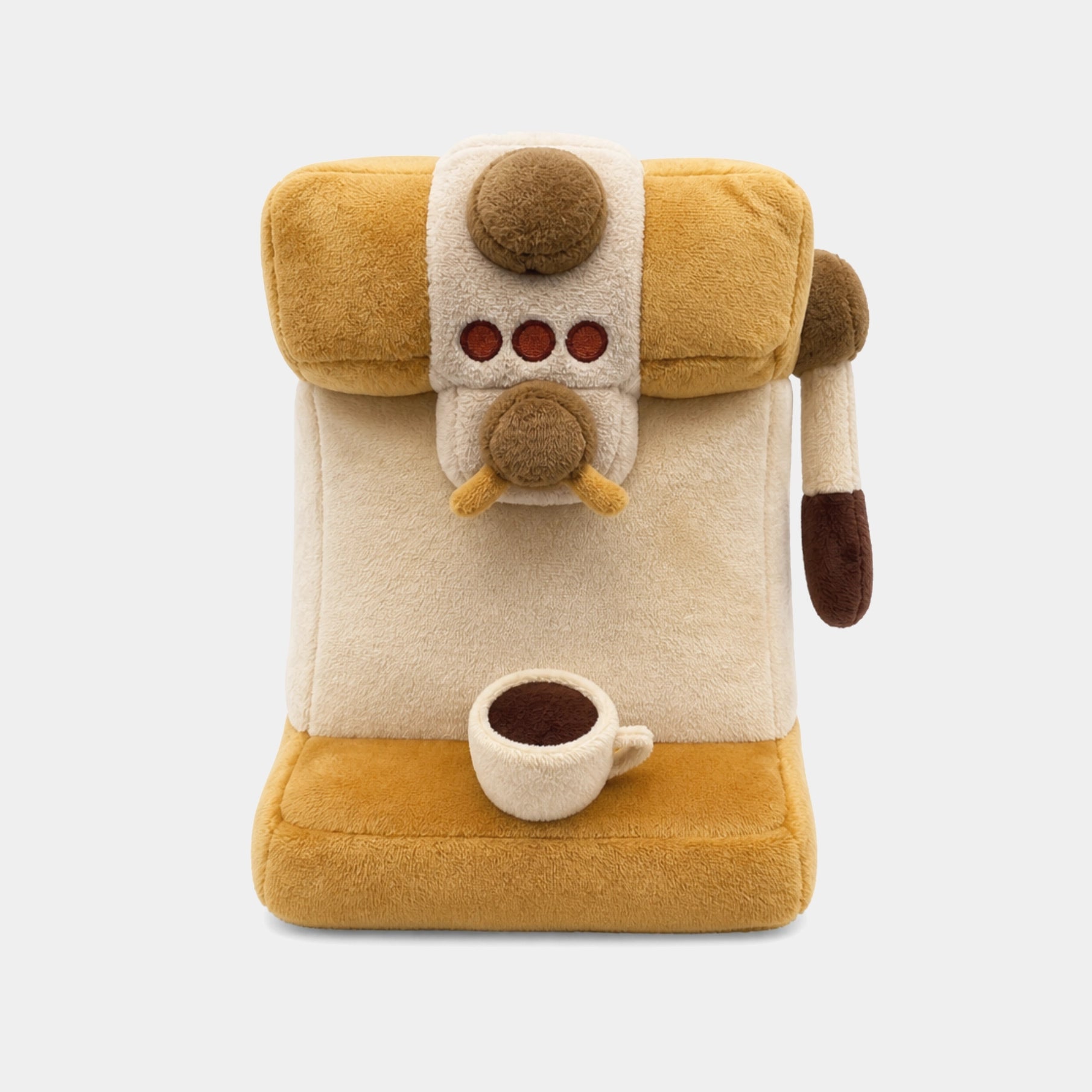 A plush toy coffee machine driver cover in a warm mustard yellow and cream color scheme, featuring a cute cartoon face with brown buttons and a small plush coffee cup on the front, set against a solid light gray background.