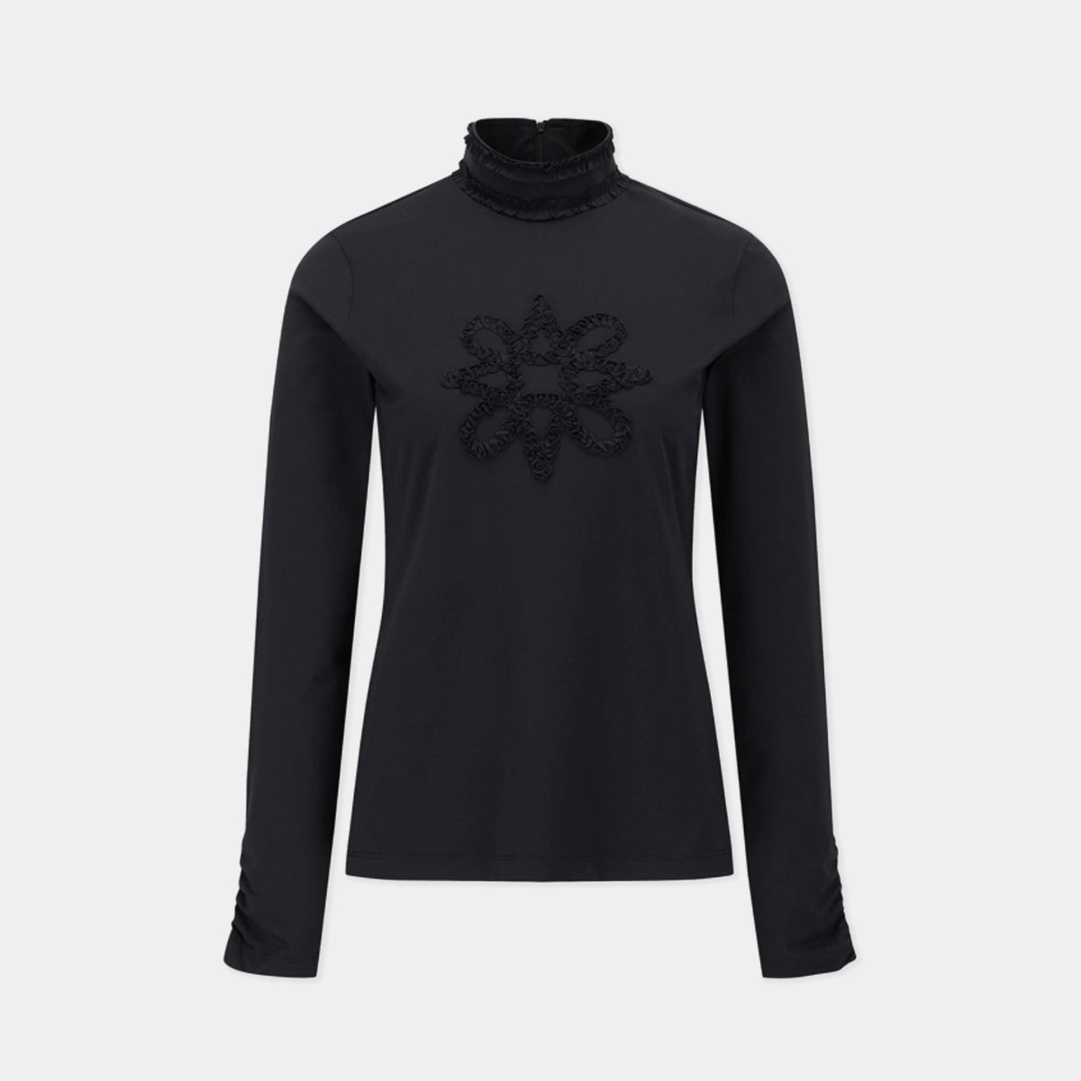 A black long-sleeve mock neck top with a textured, raised floral or starburst pattern on the center chest, displayed on a neutral light gray background.